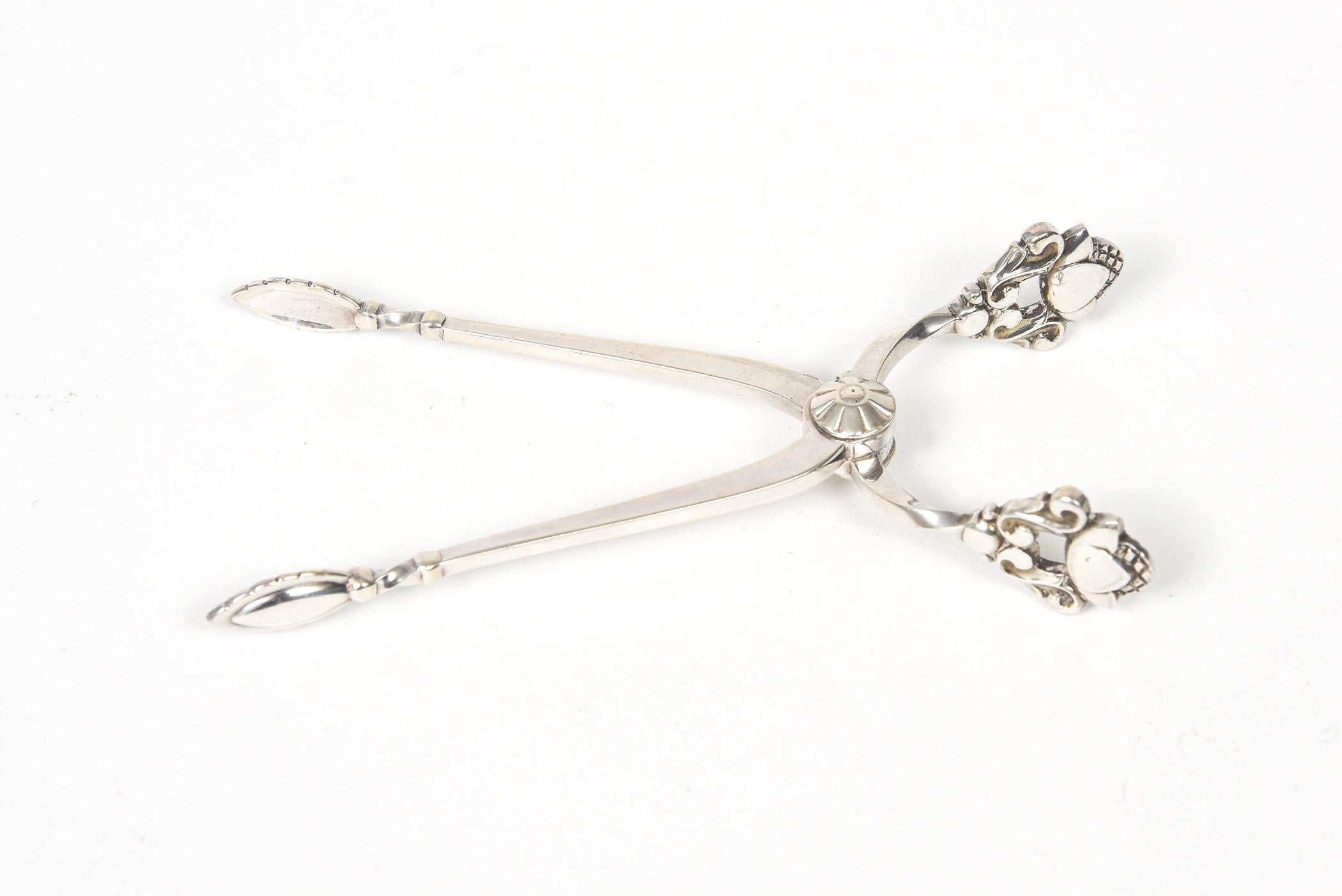 Vintage Georg Jensen sterling silver scissor shape sugar tongs from the acorn pattern introduced in 1915. Marked Sterling Denmark Georg Jensen. Current Retail is $550.