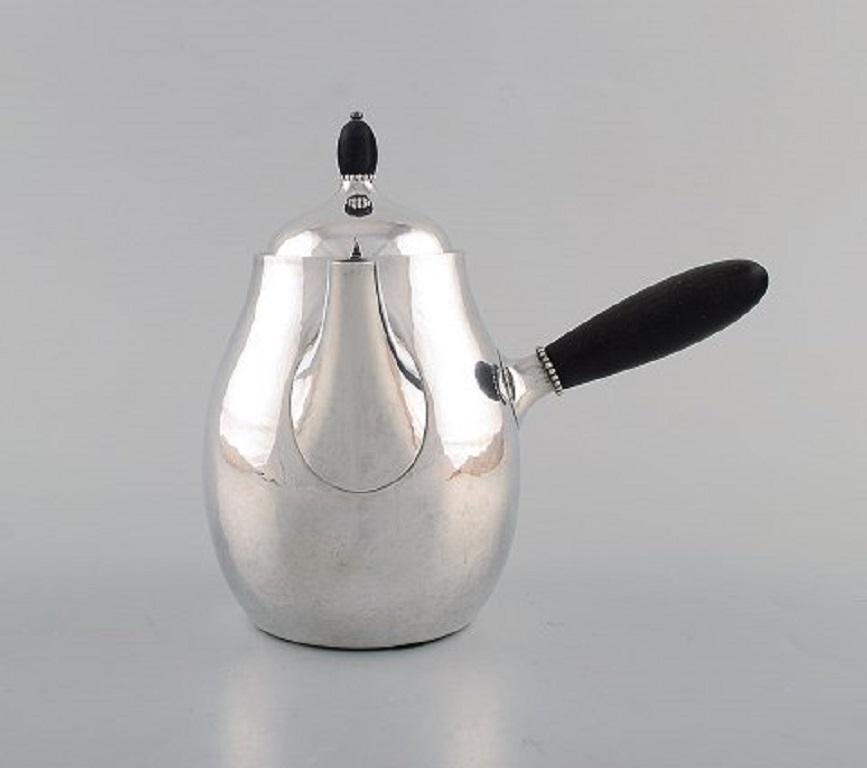 Georg Jensen Art Nouveau coffee pot with sugar bowl and creamer in sterling silver with handle and knob in ebony. Model Number 80A. Designed in 1915.
The coffee pot measures: 19.5 x 18 cm.
The creamer measures: 11.5 x 7 cm.
In very good