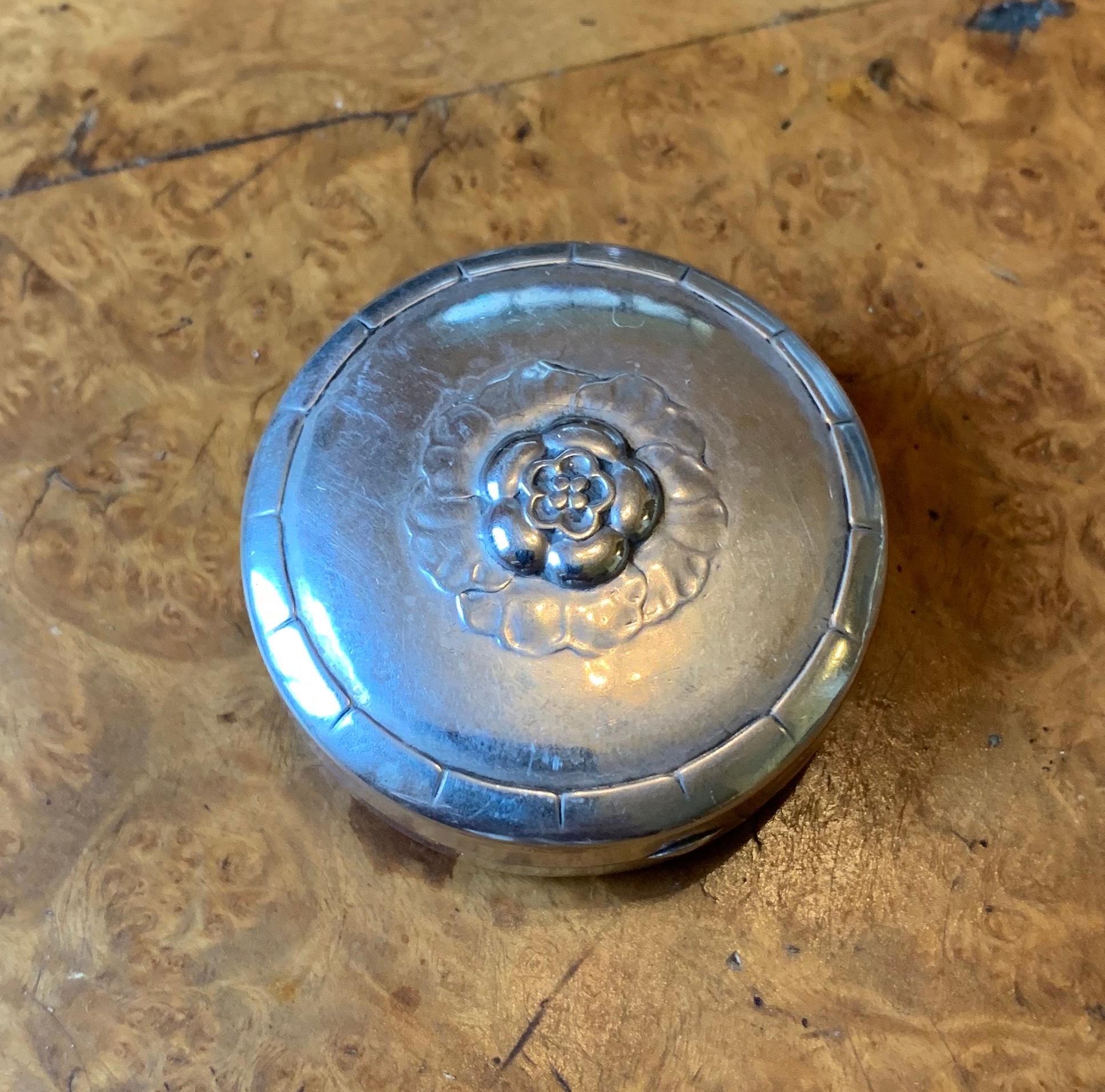 THIS IS A WONDERFUL AND RARE EARLY ORIGINAL GEORG JENSEN ART NOUVEAU DRESSER PILL JEWELRY RING BOX IN STERLING SILVER WITH A FLOWER MOTIF ON THE TOP.  This is an absolutely stunning rare early antique small silver dresser box by the master