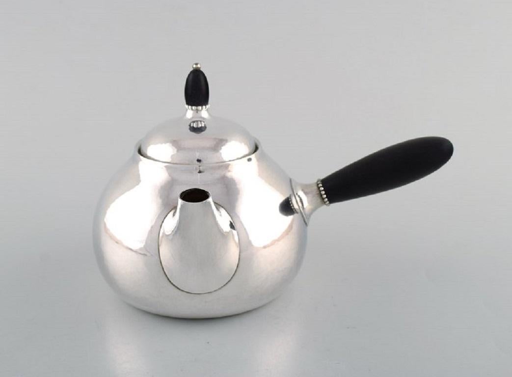 Georg Jensen Art Nouveau teapot and milk jug in sterling silver with handle and knob in ebony.
Model Number 80A/80B. 
Designed in 1915.
The teapot measures: 21.5 x 14 cm.
In very good condition.
Stamped.