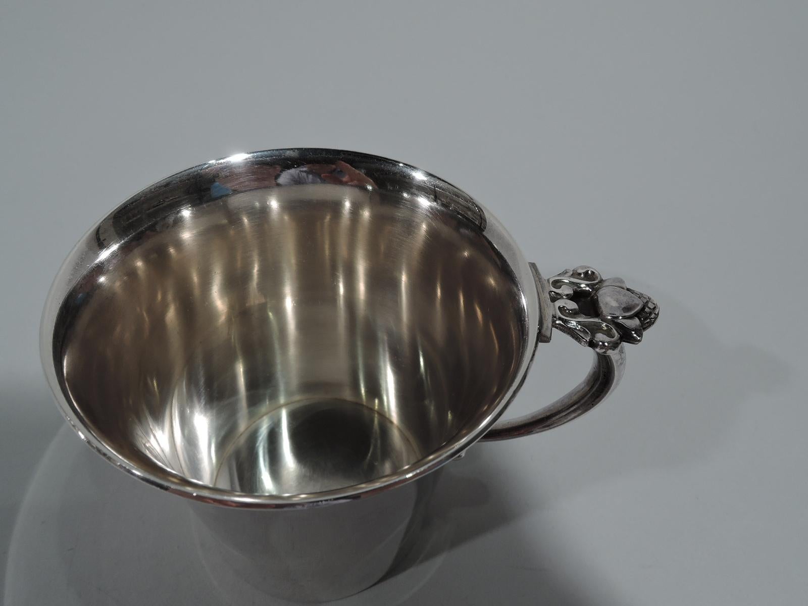 Sterling silver baby cup in symbolically potent Acorn pattern. Made by Georg Jensen in Copenhagen, after design by Johan Rohde. Straight sides, flared rim, and c-scroll handle. Handle capped with acorn. A great gift for a future oak. Early marks