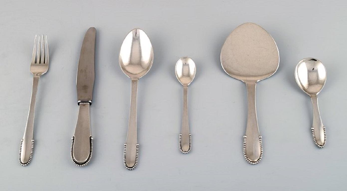 Georg Jensen Beaded complete 12 p. service.
12 knives, 12 forks, 12 tablespoons, 12 Coffee spoons in full silver, jam spoon, and serving spade.
Measures: knife 20 cm.
Stamped.
In perfect condition.
 