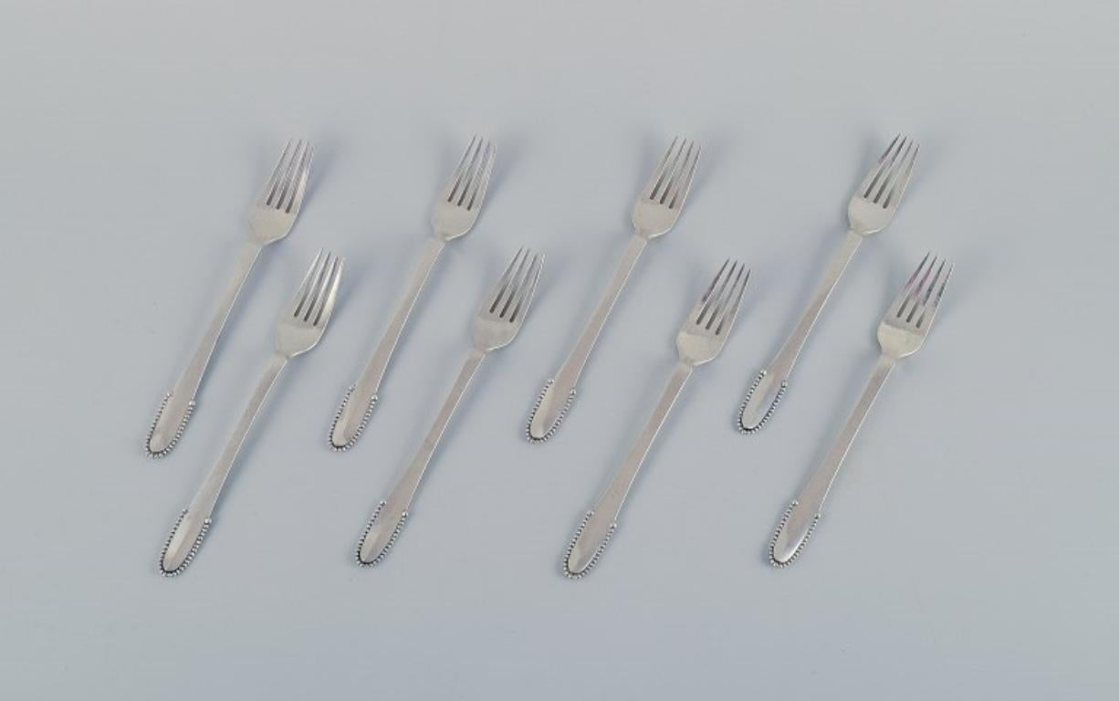 Georg Jensen Beaded.
A set of eight lunch forks in 830 silver and sterling silver (5 pcs.).
After 1944 hallmark (5 pcs.).
Early 1915-1930 hallmark (3 pcs.).
In excellent condition.
Dimensions: L 18.6 cm.