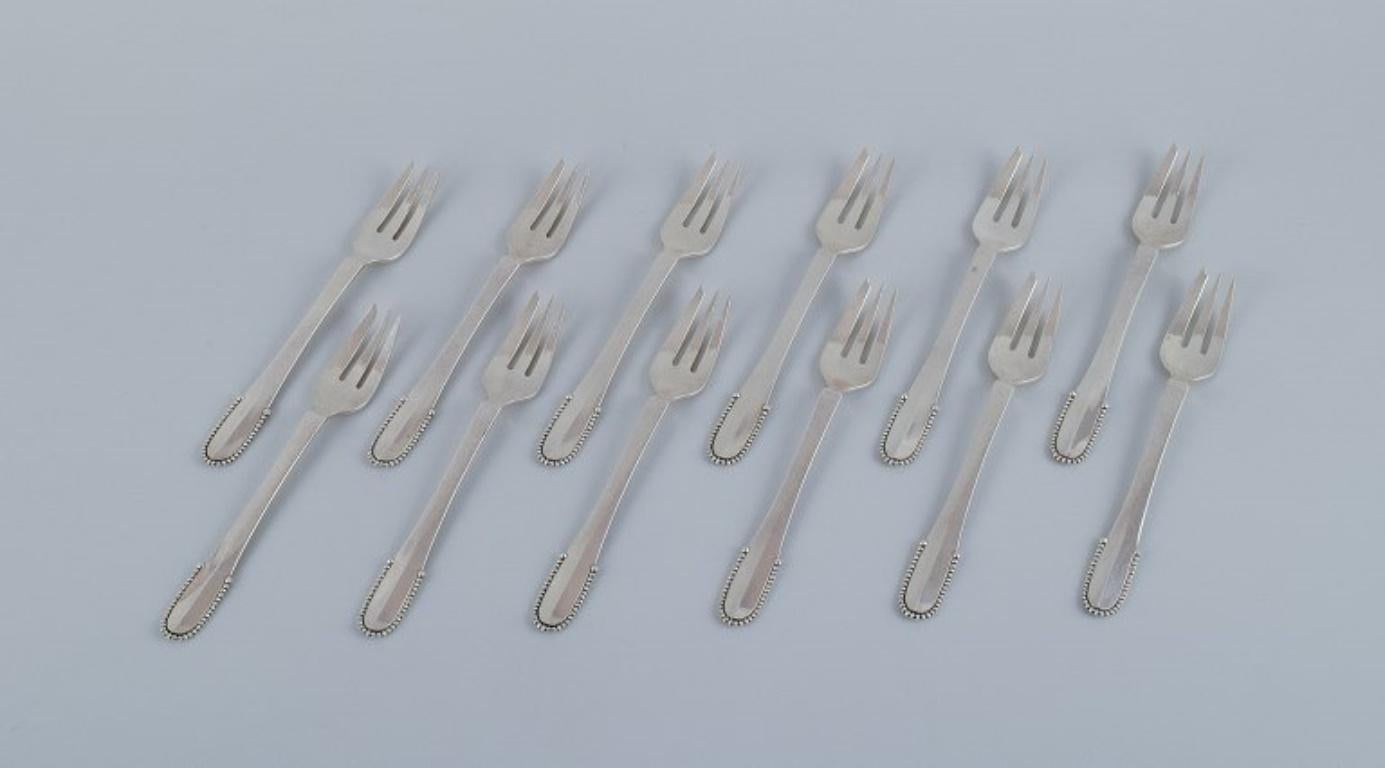 Georg Jensen Beaded.
A set of twelve cake forks in sterling silver.
Post 1945 hallmark.
In excellent condition.
Dimensions: L 14.2 cm.