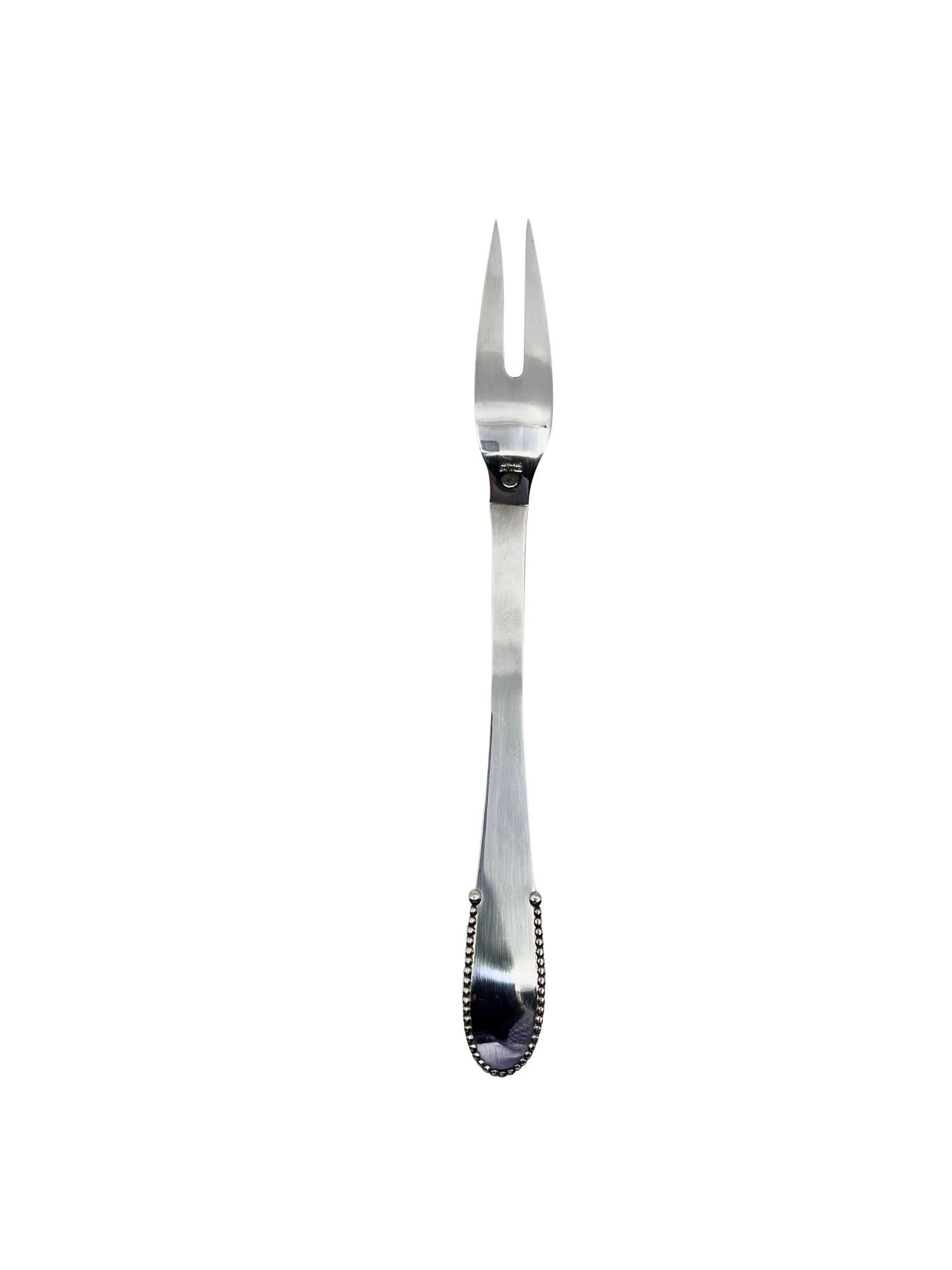 A sterling silver Georg Jensen meat fork, item #143 in the Beaded pattern, design #7 by Georg Jensen from 1916.

Additional information:
Material: Sterling Silver
Style: Art Nouveau
Hallmarks: Measures 8″ (20 cm) in length.
Dimensions: Measures 8″