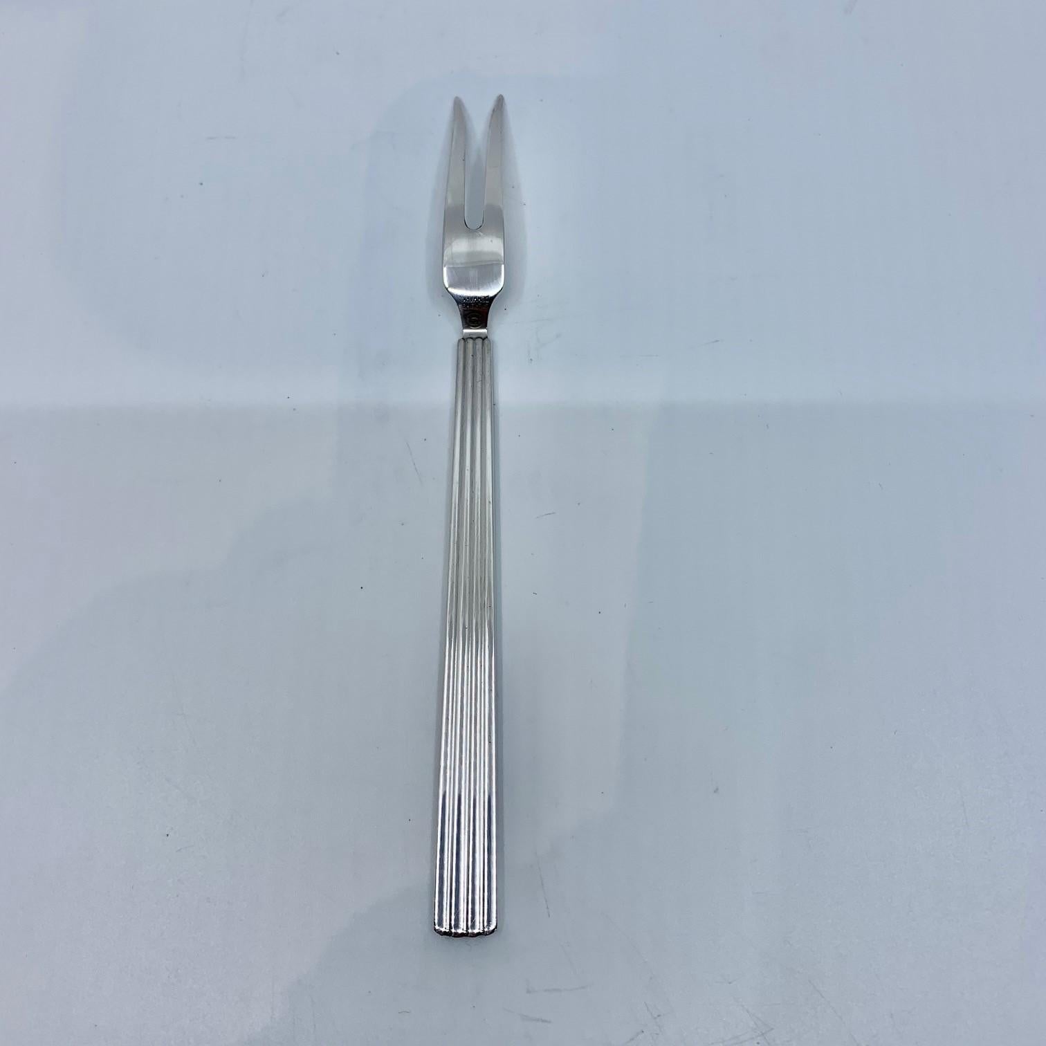 Sterling silver Georg Jensen cold cuts fork, item 144 in the Bernadotte pattern, design #9 by Sigvard Bernadotte from 1939.

Additional information:
Material: Sterling Silver
Style: Art Deco
Hallmarks: With Georg Jensen hallmark, made in