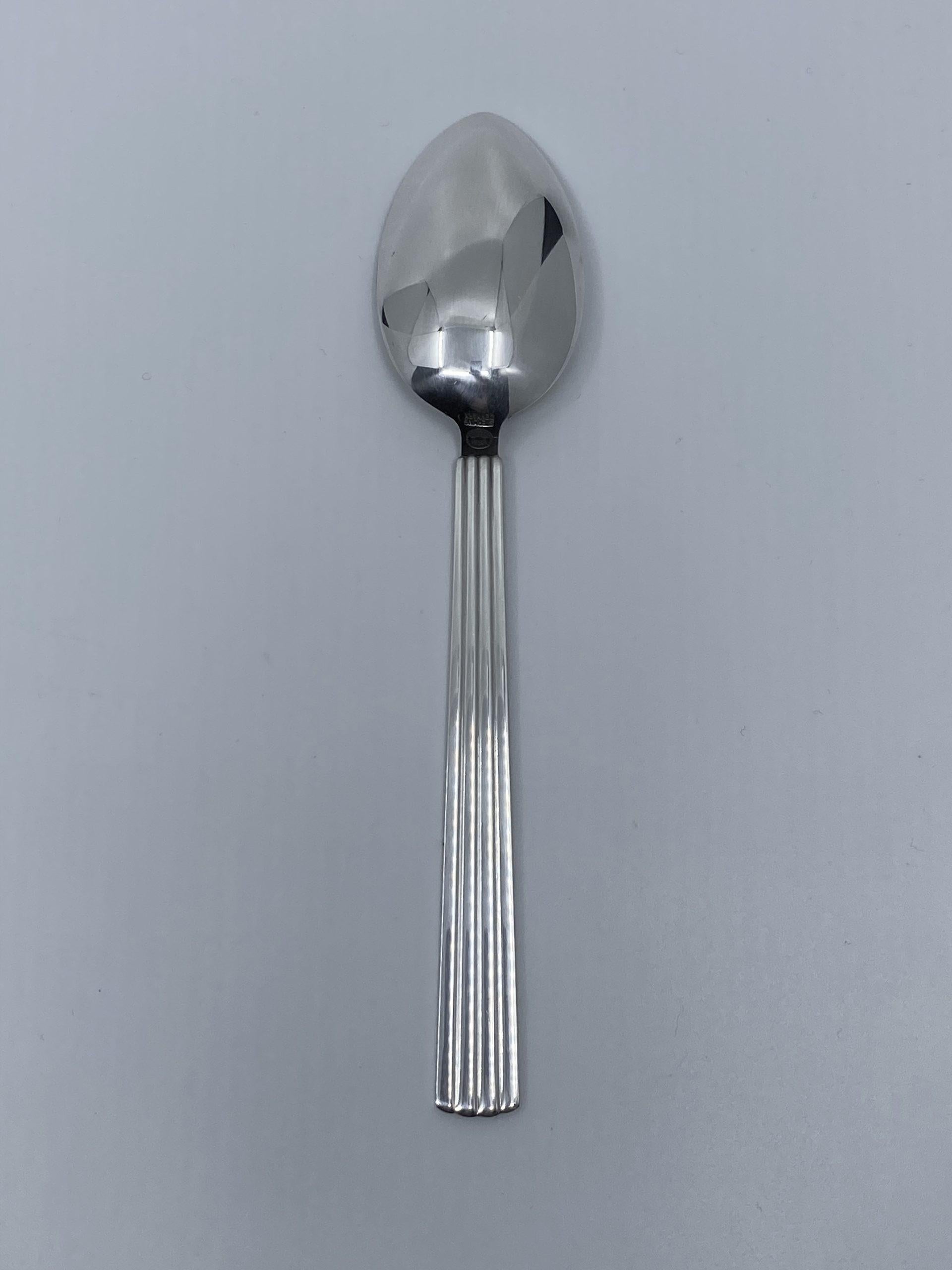 A sterling silver Georg Jensen dessert spoon, item #021 in the Bernadotte pattern, design #9 from 1939 by Sigvard Bernadotte.

Additional information:
Material: Sterling silver
Styles: Art Deco
Hallmarks: With Georg Jensen hallmark, made in