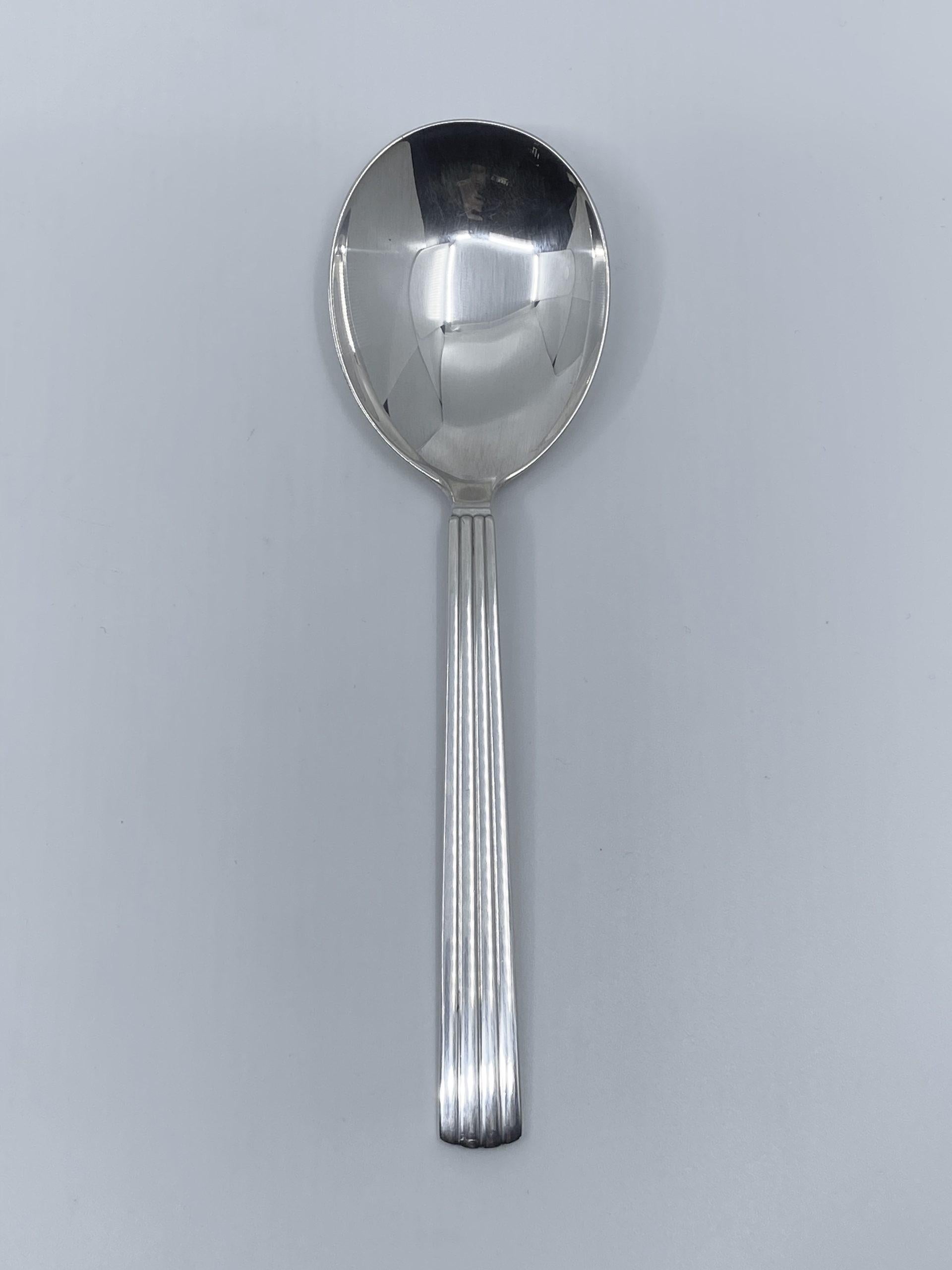 Sterling silver Georg Jensen serving spoon, item 115 in the Bernadotte pattern, design #9 by Sigvard Bernadotte from 1939.

Additional information:
Material: Sterling silver
Style: Art Deco
Hallmarks: With Georg Jensen hallmark, made in