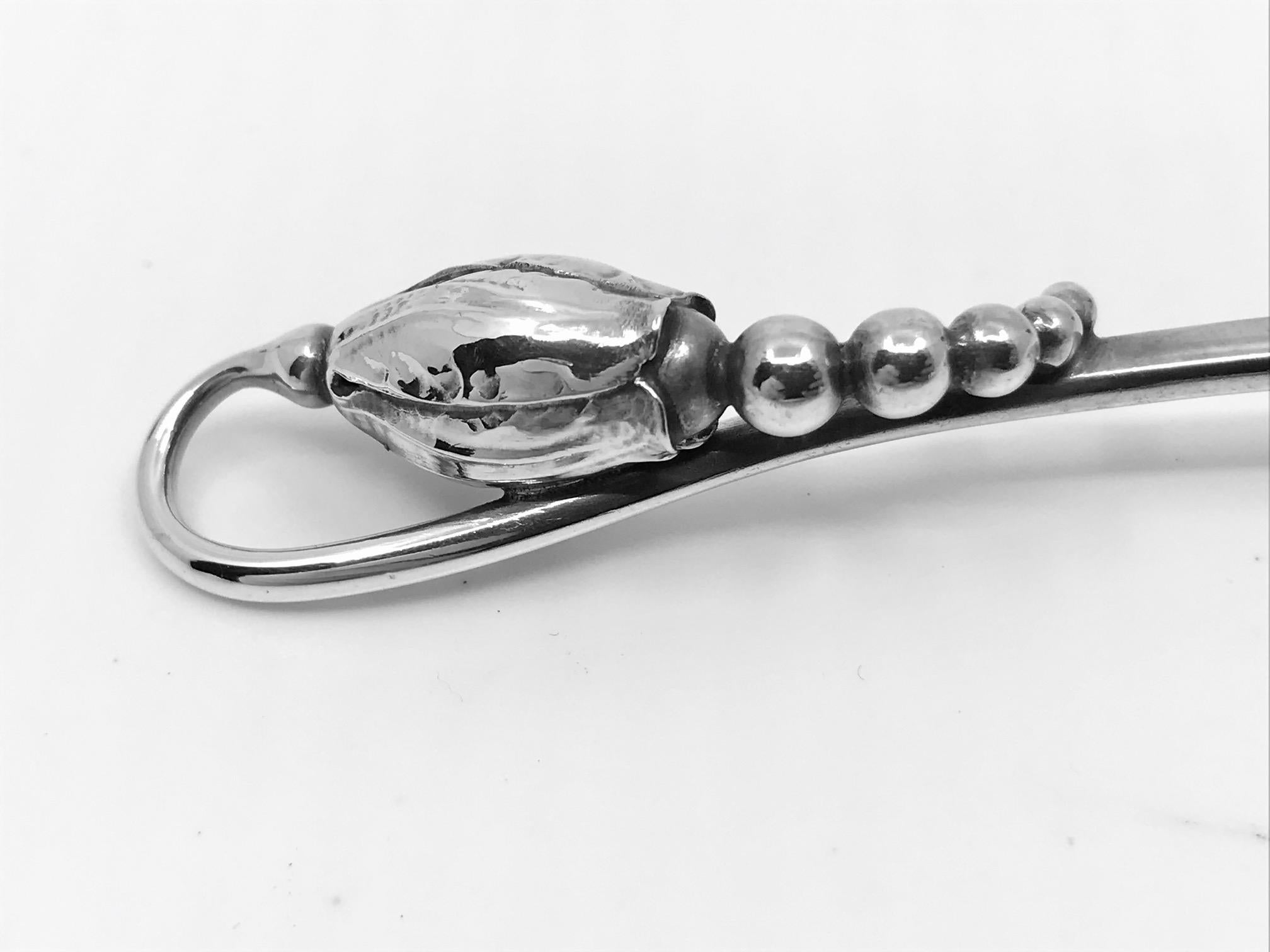 This is a sterling silver Georg Jensen gravy ladle, item 153 in the Blossom/Magnolia pattern, design #84 by Georg Jensen from 1919.

Additional information:
Material: Sterling silve
Style: Art Nouveau
Hallmarks: With Georg Jensen hallmark, made in