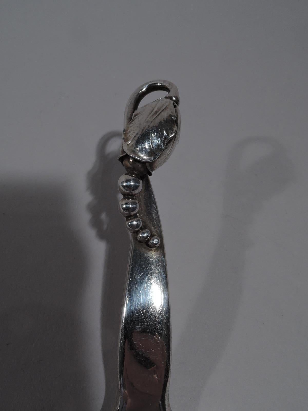 Blossom sterling silver pastry server. Made by Georg Jensen in Copenhagen. The Classic terminal with seeds spilling out of bud. Blade flat and triangular. A beautiful piece in the pattern designed by the master. Postwar marks include pattern no. 84.