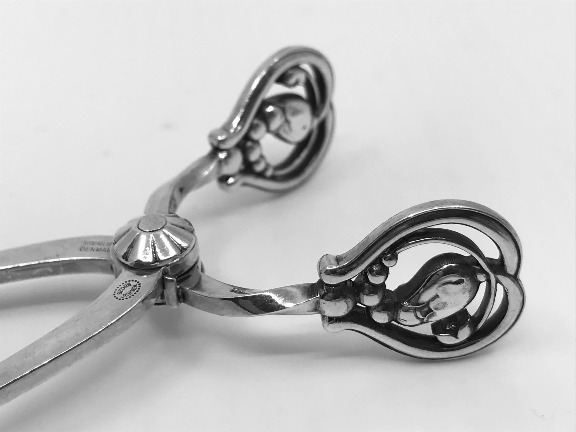 Sterling silver Georg Jensen Blossom sugar tongs, design by Georg Jensen.

Additional Information:
Material: Sterling Silver
Style:  Art Nouveau
Hallmarks: We have three pairs, one with Georg Jensen hallmark from 1922, one from the 1930s and one