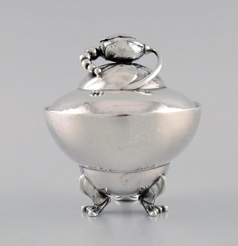 Georg Jensen Blossom sugar bowl in hammered sterling silver. Model 2D. 
Dated 1925-1932.
Measures: 11.5 x 10.2 cm.
In excellent condition. Minimal age-related wear.
Stamped.
Our skilled Georg Jensen silversmith / goldsmith can polish all silver