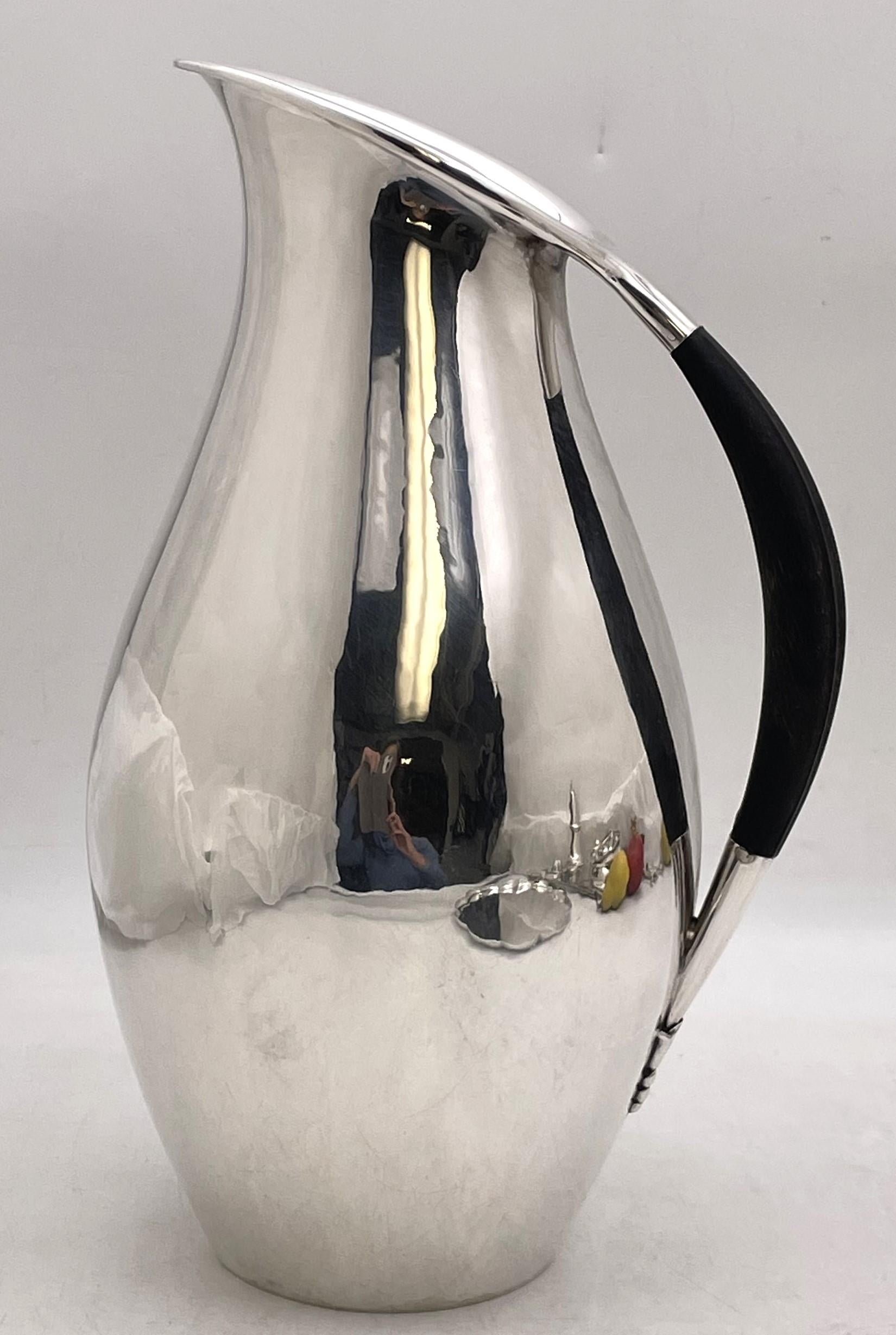 Georg Jensen sterling silver pitcher, designed by Johan Rohde, in pattern number 432F, beautifully hand-hammered with an elegant design and an ebony wood handle. It measures 11 1/3'' in height by 6 3/4'' in depth, weighs 31 troy ounces, and bears