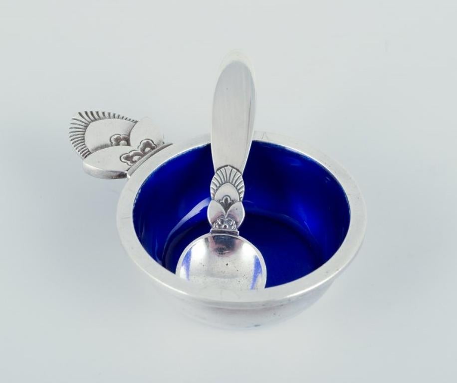 Georg Jensen Cactus. Salt cellar in sterling silver with accompanying salt spoon. Interior with royal blue enamel.
Model number 30.
Hallmarked after 1944.
In perfect condition.
Spoon: Length 5.5 cm.
Salt cellar: Length 6.5 cm. x 1.5 cm.