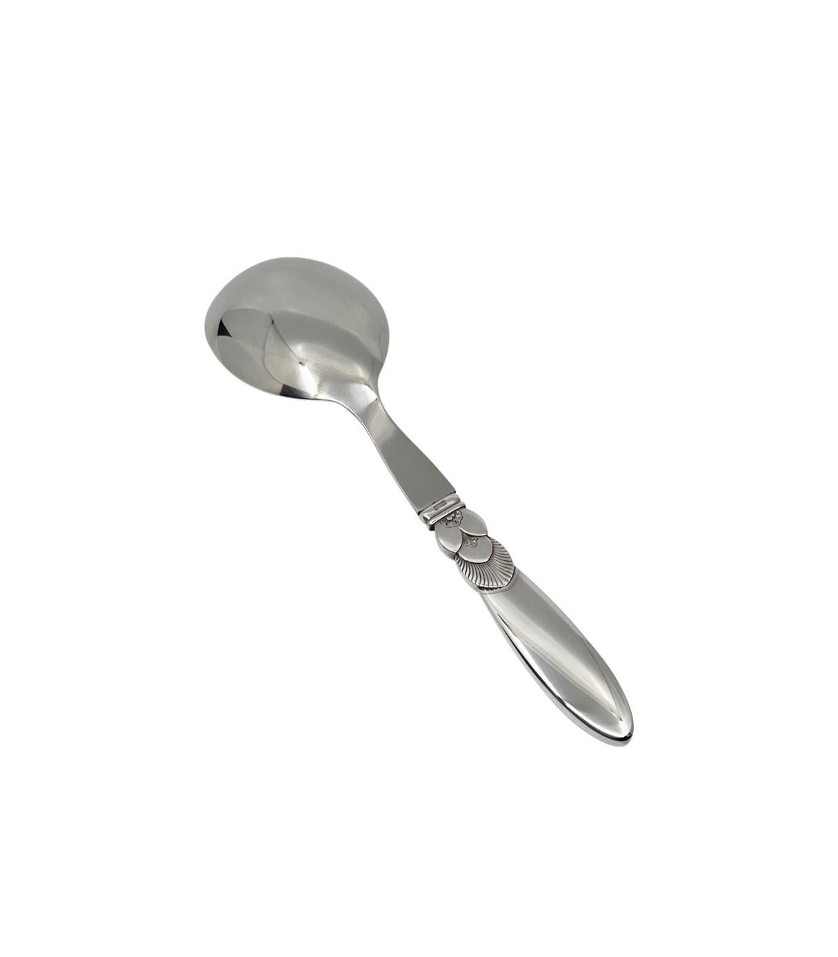 A Georg Jensen cactus sterling silver and stainless steel bowl serving spoon, item 121 in the Cactus pattern, design #30 by Gundorph Albertus from 1930.

Additional information:
Material: Sterling silver
Hallmarks: Georg Jensen hallmarks from