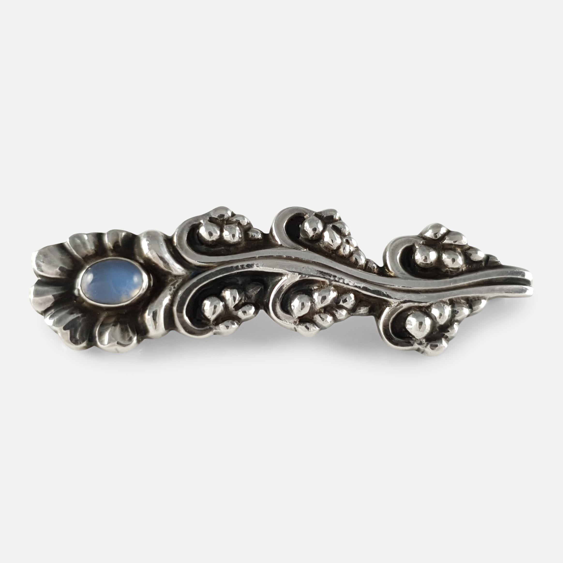 Description: - A superb Georg Jensen silver and moonstone brooch #104, circa 1933-1944.  The brooch is of floral spray-design and set with a moonstone cabochon. The brooch is stamped with the GJ makers marking (used from 1933-1944), 925 mark to