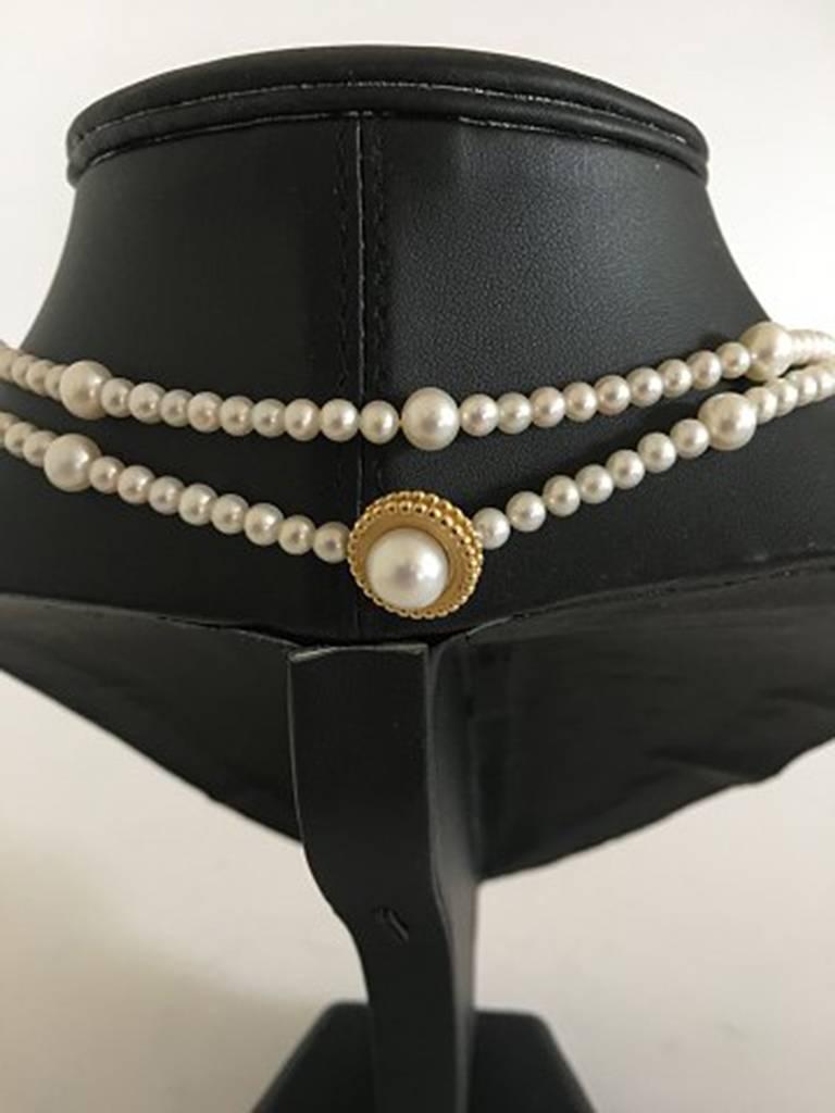 Georg Jensen Collier with White Freshwater Cultured Pearls and Gold Lock. 88 cm L (34 41/64 in.). Round pearls in beautiful condition. A collier offers several styling options. The Pearl Are 4 mm and the large ones are 7mm.