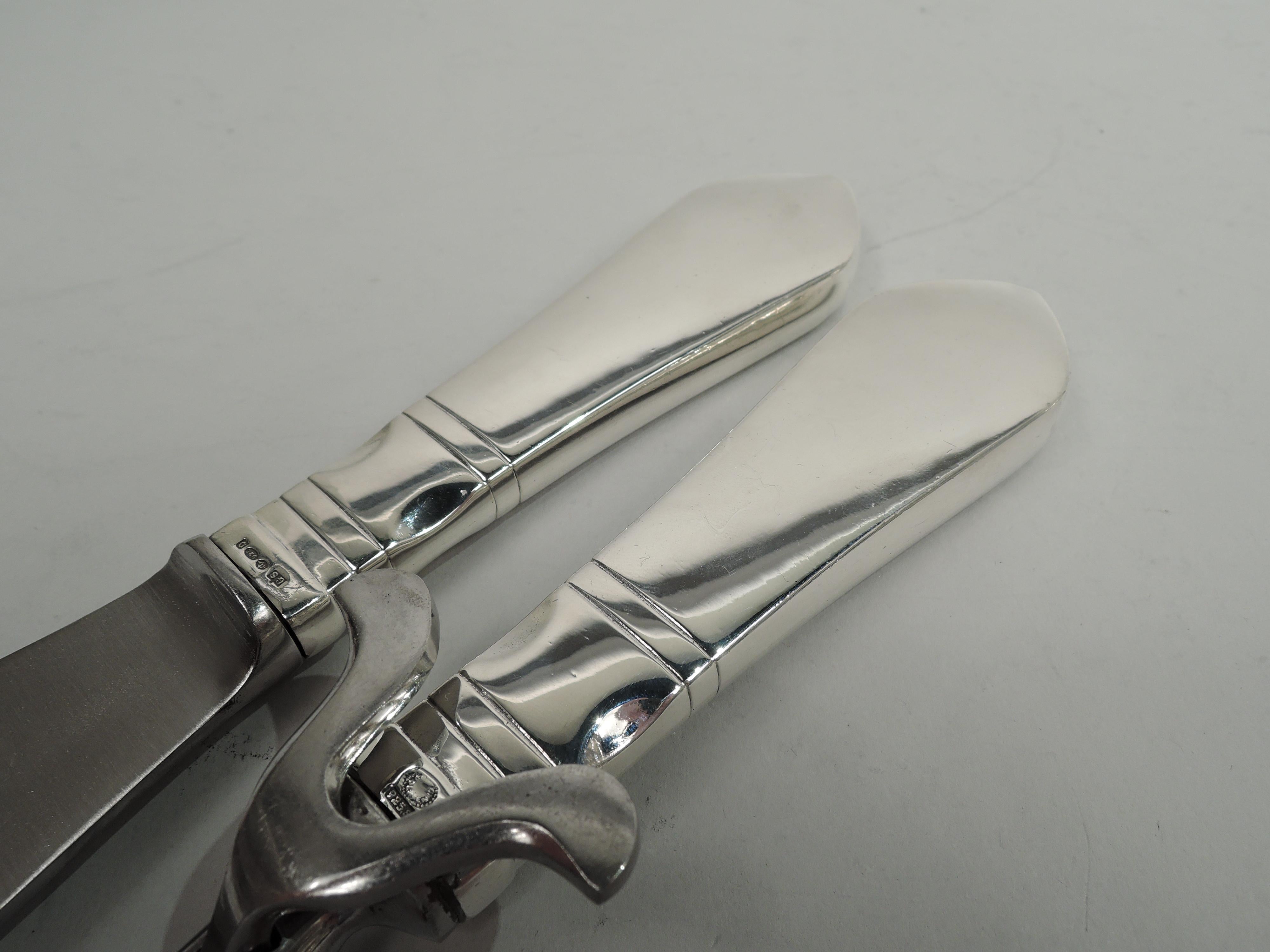 Continental sterling silver carving pair. Made by Georg Jensen in Copenhagen, and imported in 1929 to England by George Stockwell. Upward tapering handle with tooled bands; convex terminal with engraved armorial. Stainless steel blade (knife) and