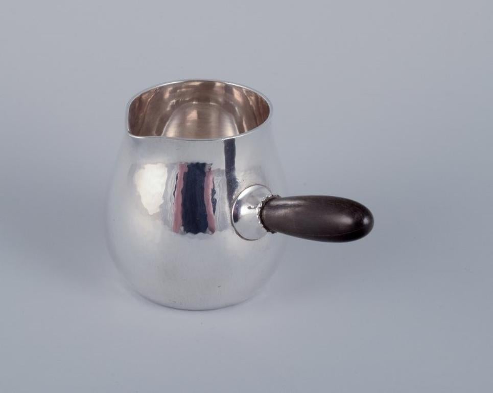 Cremiera Georg Jensen in argento sterling con manico in ebano.
Model 80A.
In ottime condizioni, con crepe naturali nel manico in legno.
Marchiato dopo il 1944.
Dimensioni: Lunghezza 10,3 cm compreso il manico x Altezza 6,3 cm.
