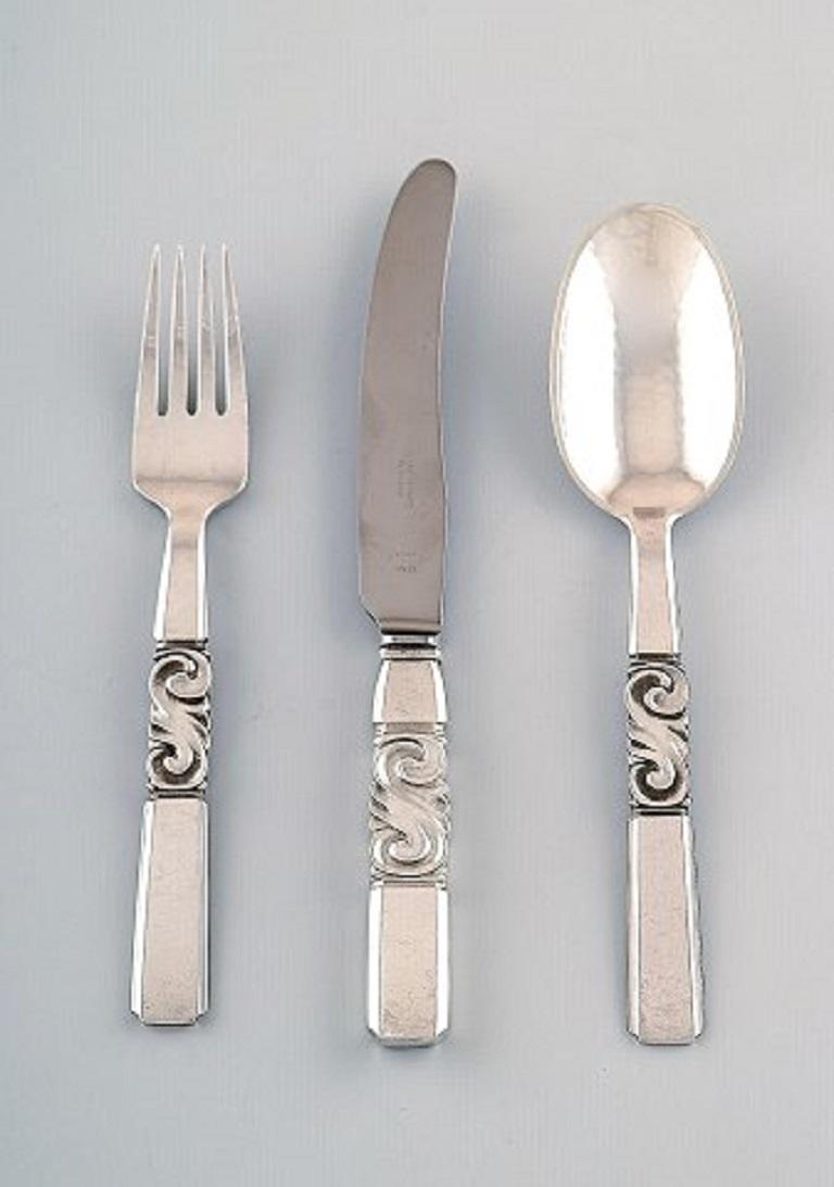 Georg Jensen. Cutlery, scroll no. 22, full lunch service of hammered sterling silver consisting of:
Six luncheon knives, six luncheon spoons, six dessert spoons.
In perfect condition
Stamped.
Knife measures: 16.5 cm.