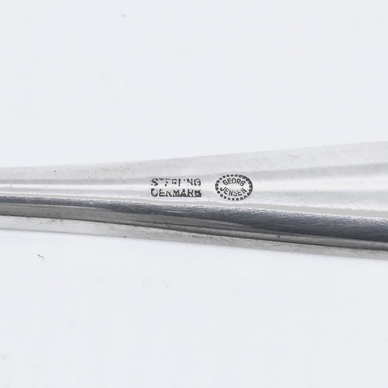 Georg Jensen Karabinerhaken aus Sterlingsilber, Artikel 065 im Zypressenmuster, Design #99 von Tias Eckhoff. Die Zypresse des norwegischen Designers Tias Eckhoff war der Siegerentwurf eines Wettbewerbs, bei dem es darum ging, ein Besteckmuster für