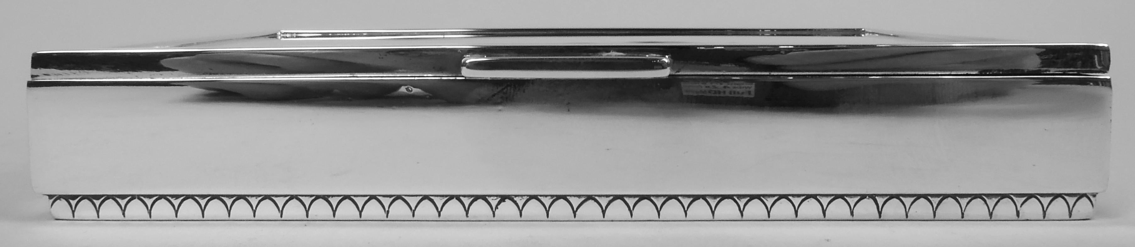 Scatola danese moderna classica in argento sterling. Prodotto da Georg Jensen a Copenhagen. Rettangolare con lati dritti; piede corto con incisione a uovo e dardo. Il coperchio è incernierato con una staffa aperta e ha un bordo piatto in rilievo.
