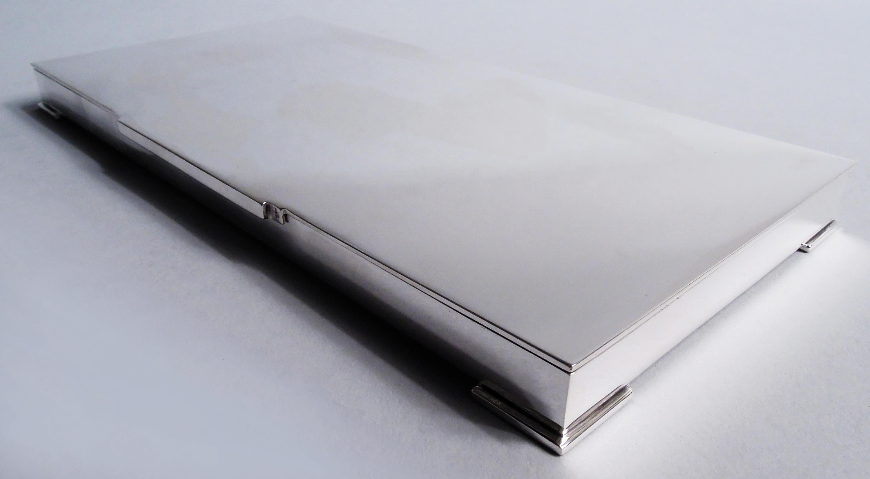 Caja moderna danesa de plata de ley. Fabricado por Georg Jensen en Copenhague. Larga y rectangular con lados rectos; soportes de esquina cuadrados. Tapa plana y abatible con lengüeta escalonada recortada. Un austero diseño clásico de Harald Nielsen.