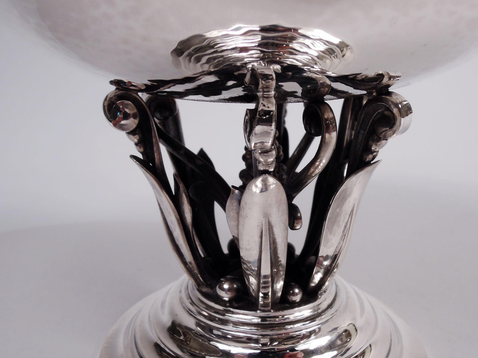 Ciotola moderna danese con piede in argento sterling. Prodotto da Georg Jensen a Copenhagen. Ciotola ampia e ricurva montata su un supporto aperto che comprende bacche incastonate in viticci e circondate da volute di viticci e perline. Martellamento
