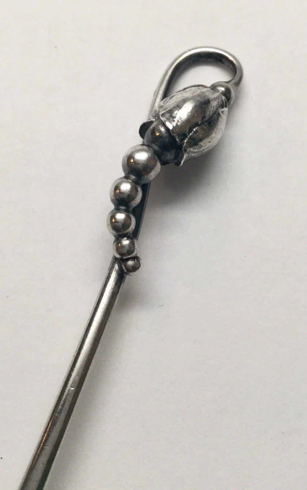 Georg Jensen Denmark hammered sterling silver coffee spoon in the blossom 84 pattern. Marked: GEORG JENSEN in dotted oval, STERLING DENMARK 84. Measures: 4 1/8