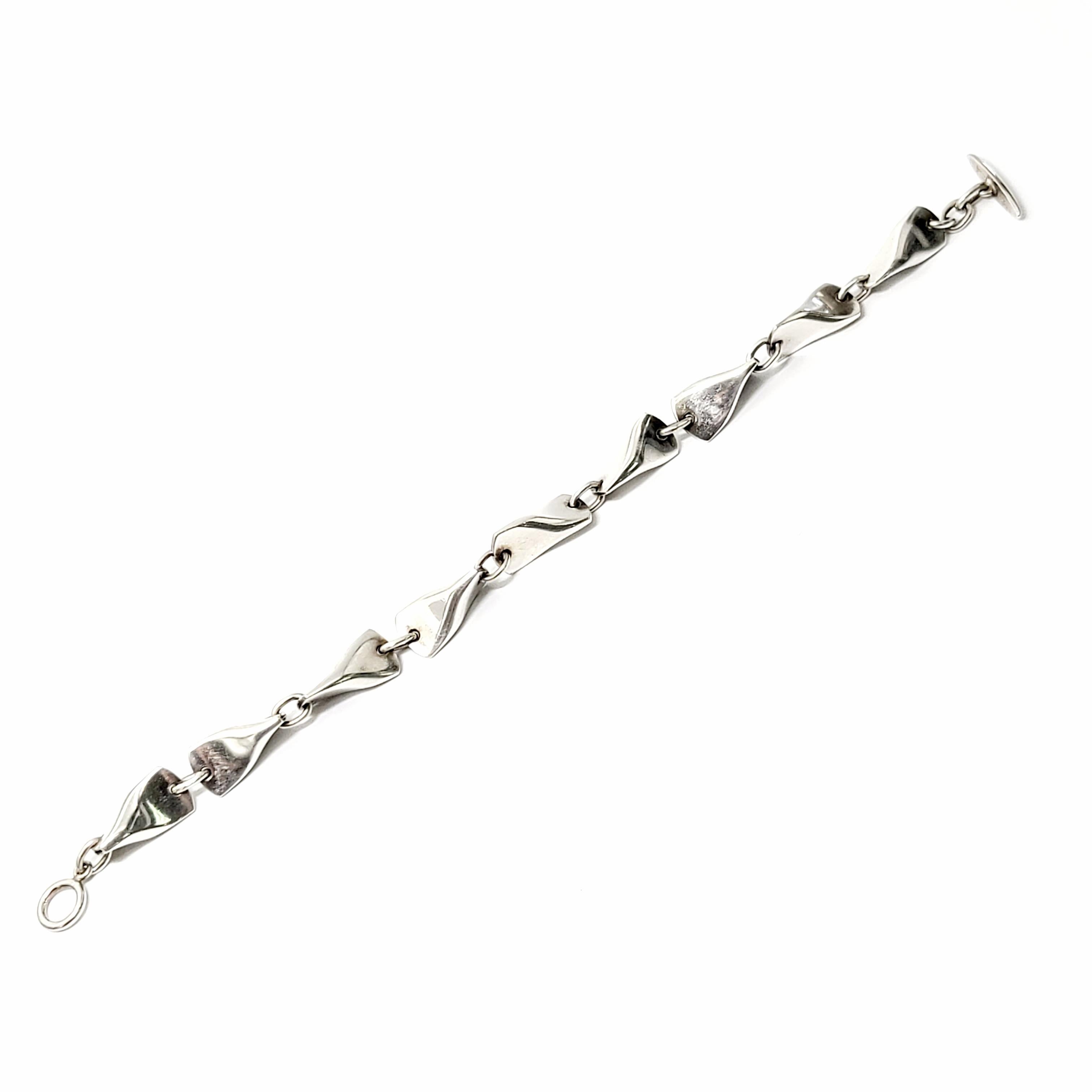 Vintage Georg Jensen sterling silver butterfly bracelet, pattern #104A.

Designed by Edvard Kindt-Larsen in 1955, this bracelet features pinched links with a toggle closure.

Measures 8