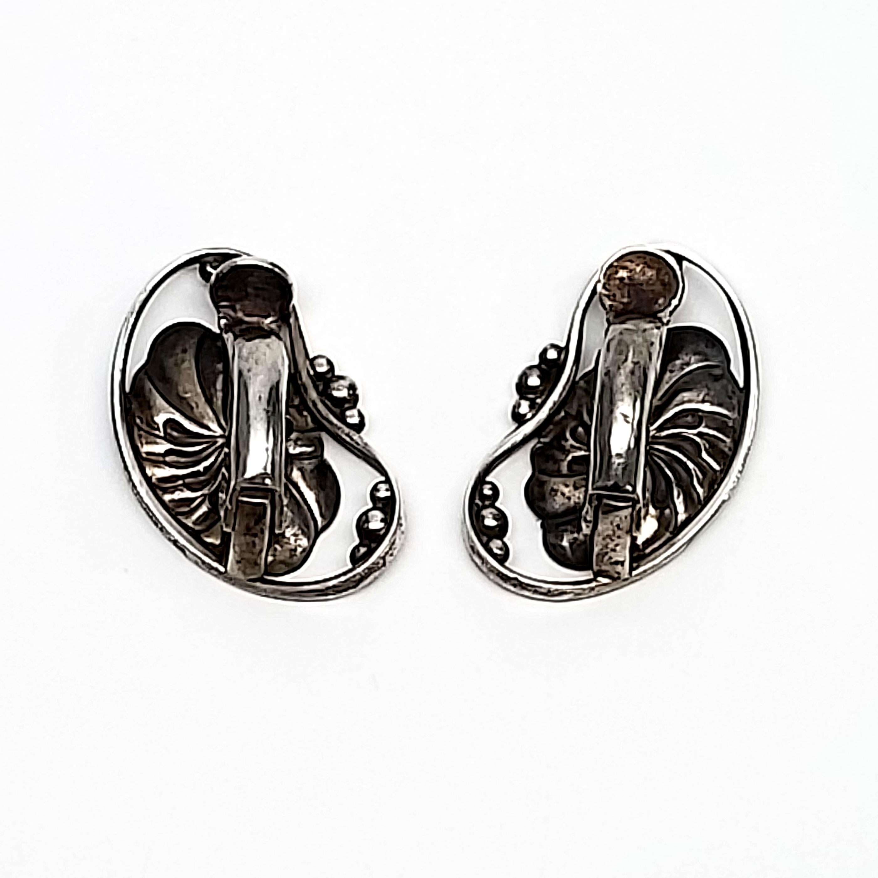 Vintage Georg Jensen sterling silver #52 Flower Bean clip-on earrings, circa 1950s.

These beautiful bean shaped earrings feature a flower and small ball accents. Originally launched in the 1950s and continues to be a classic today. Clip-on