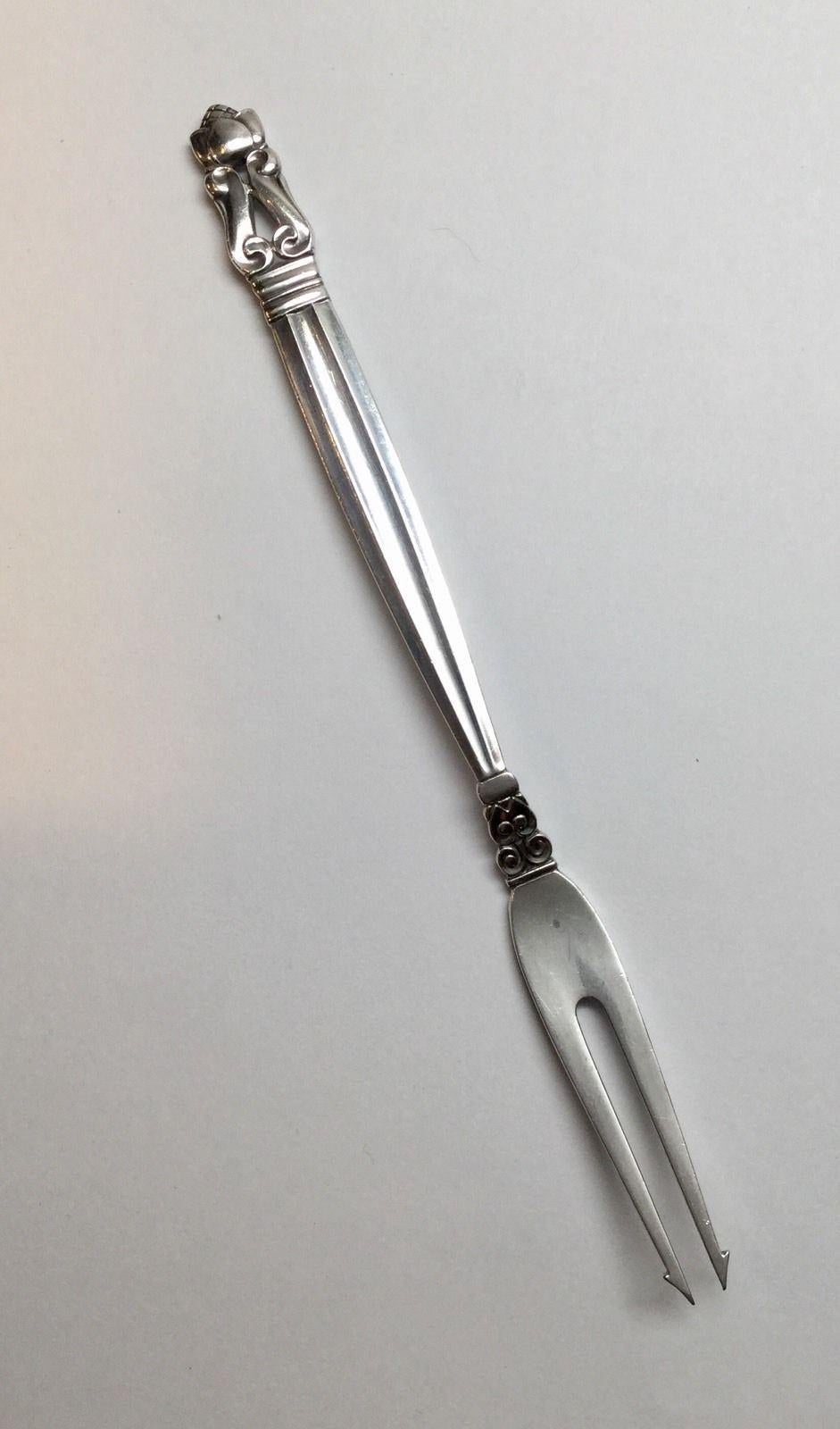 Georg Jensen Denmark sterling silver barbed two tine fork. 
Marked: GJ in dotted oval, Sterling, Denmark. 
No monogram. 
Dated: 1915-1932. 
Measures: 6 1/4