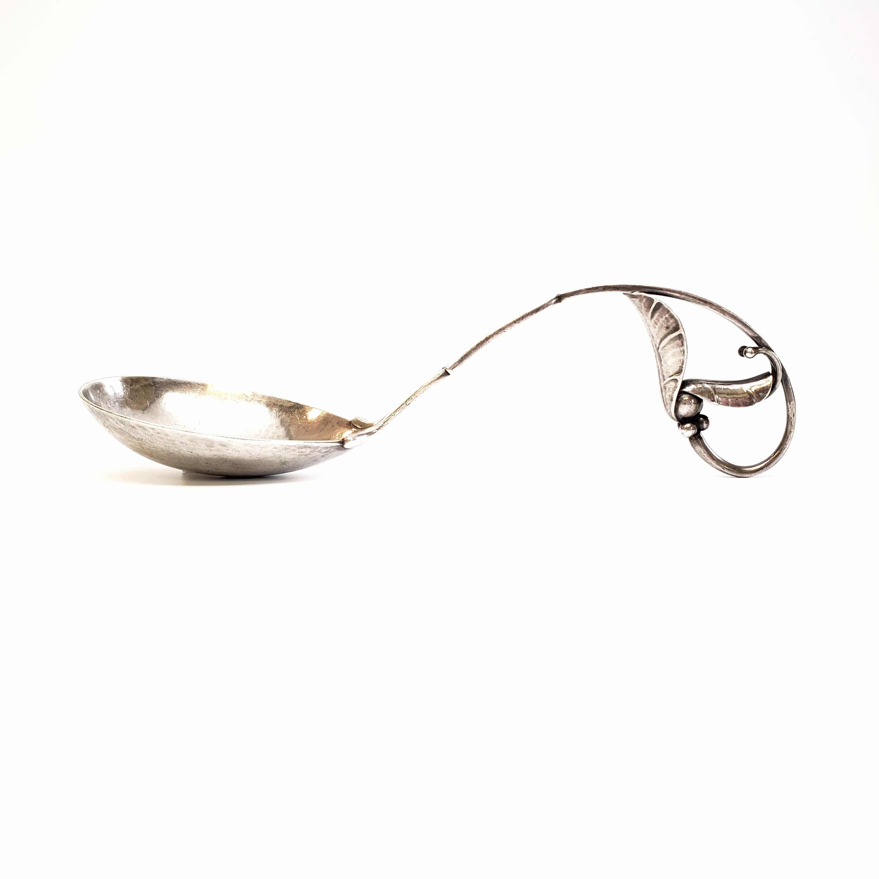 Vintage Georg Jensen Denmark sterling silver ladle in the Blossom pattern, #141.

Dated 1910-1925, this beautiful ladle features a hammered oval bowl, with a beautifully ornate curved handle with leaf designs.

Monogram appears to be