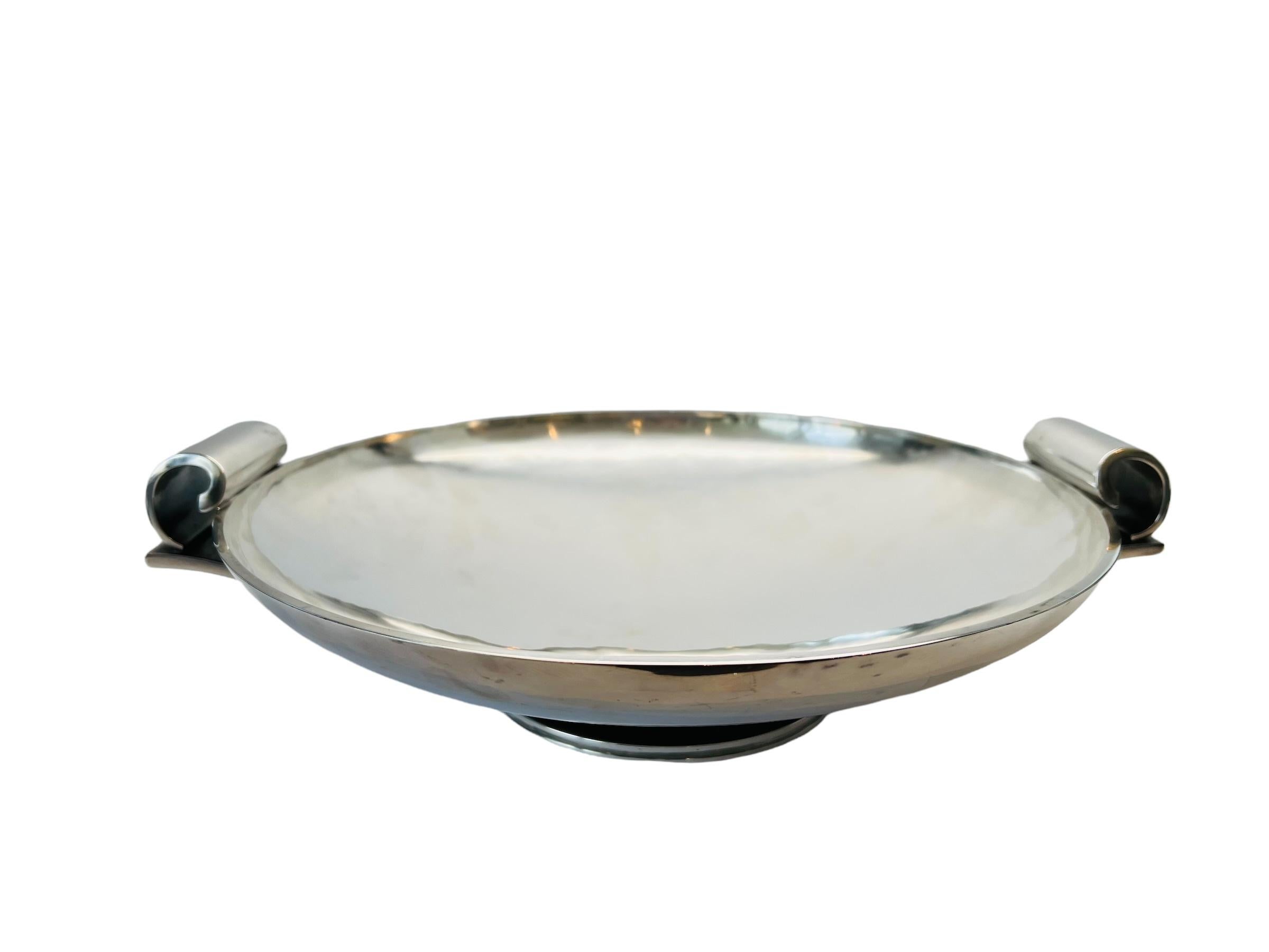 Georg Jensen Denmark sterling silver Art Deco rolled handle centerpiece bowl by Harald Nielsen 752B.

Marked: Georg Jensen in dotted oval dating 1945 to present, Denmark, Sterling, 752B, Dessin HN

Bowl measures 13 7/8