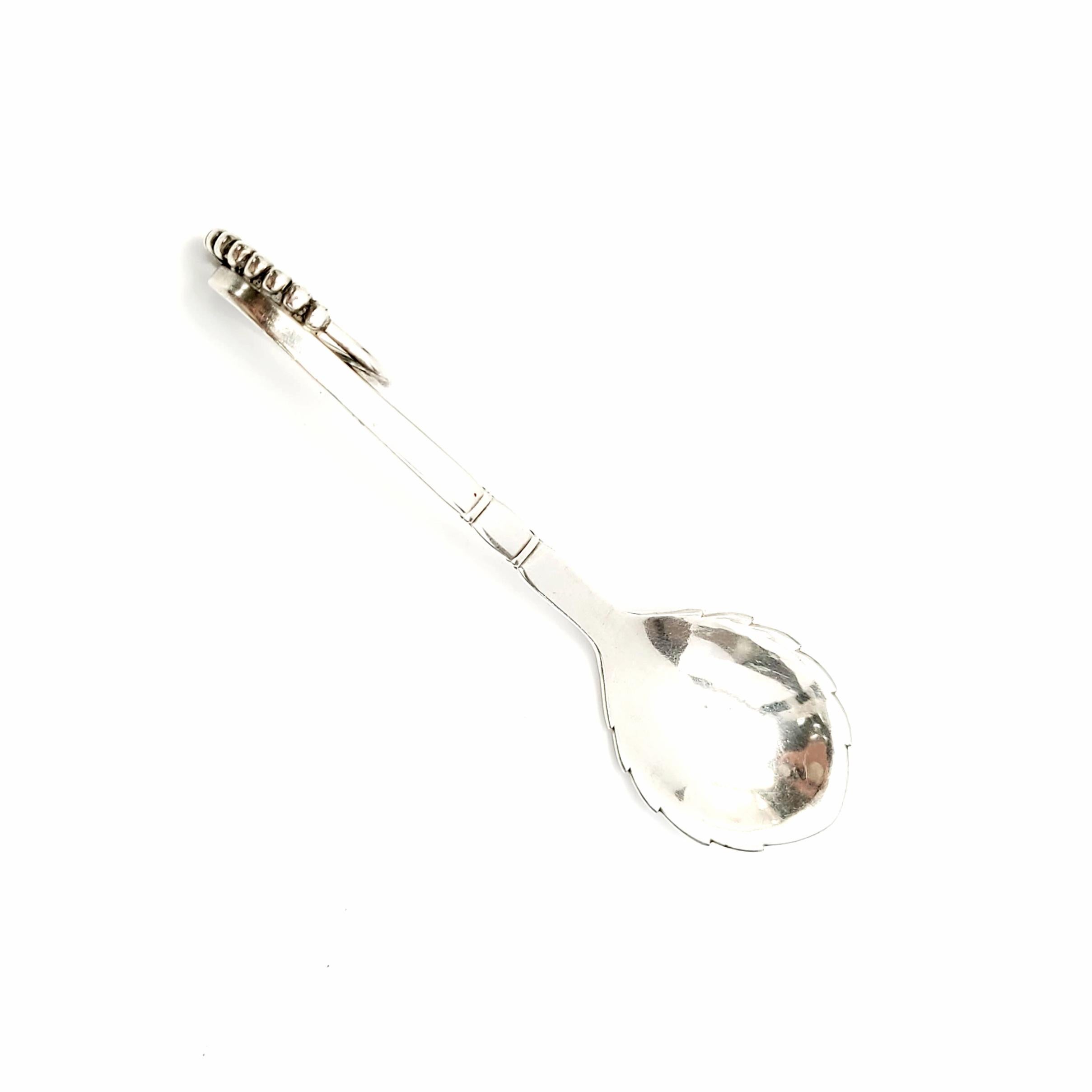 Vintage Georg Jensen Denmark sterling silver sugar spoon in the Ornamental #41 pattern.

Dated 1910-1925, this beautiful ladle features a lightly hammered bowl, with a beautifully ornate curved handle featuring a swirl of seed-like small silver