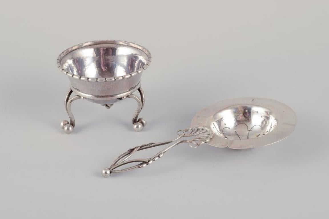Georg Jensen, early tea strainer with holder. 830 silver.
Model number 10.
Marked with 1915-1932 hallmark as well as Swedish import hallmarks.
In excellent condition.
Strainer: Length 15.5 cm x Height 2.0 cm.
Holder: Diameter 7.5 cm x Height 5.5 cm.