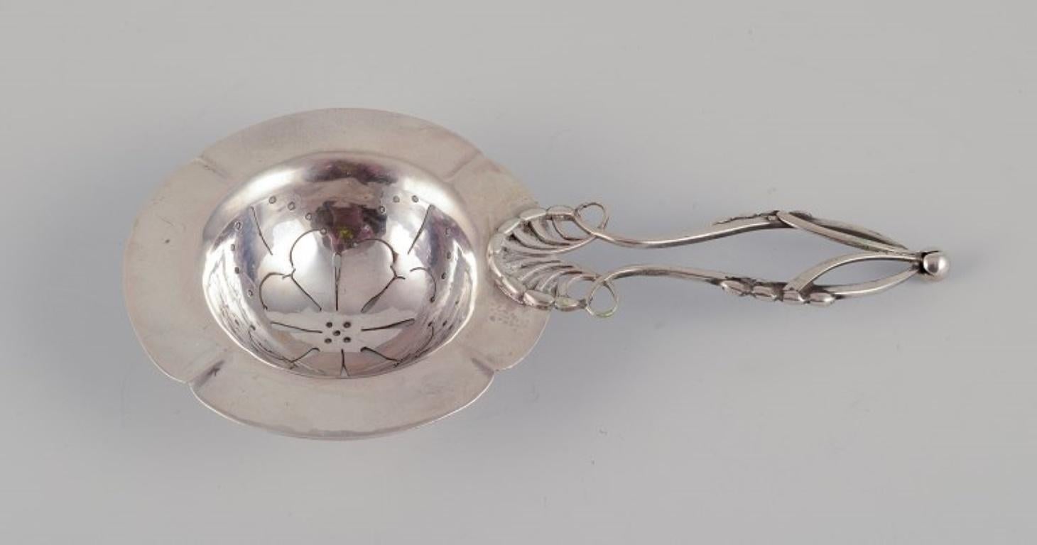 Early 20th Century Georg Jensen, early tea strainer with holder in 830 silver.