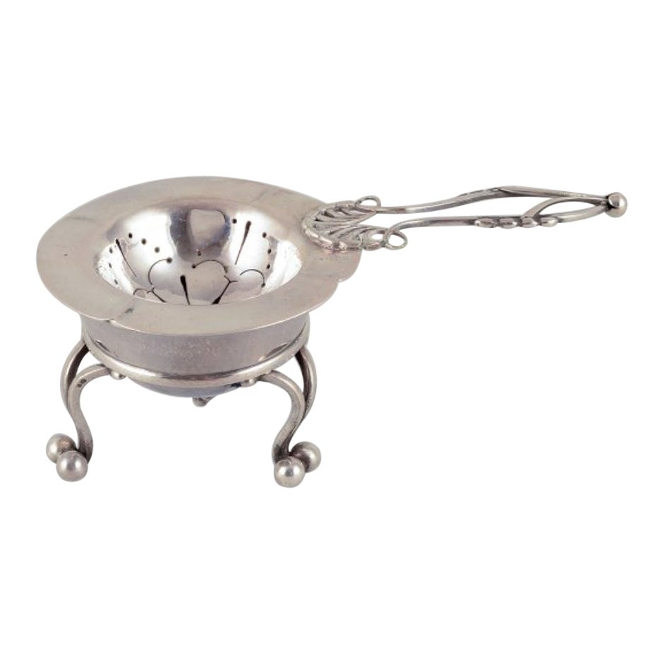 Georg Jensen, early tea strainer with holder in 830 silver.