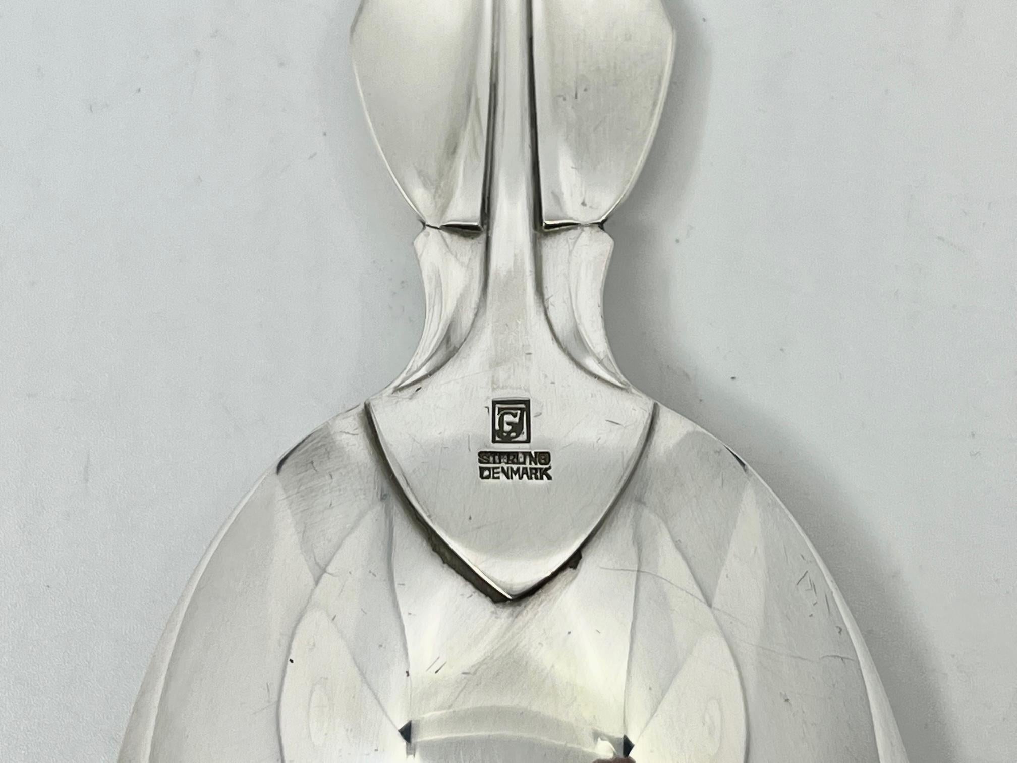 A sterling silver Georg Jensen large serving spoon, item #111 in the Elsinore pattern, design #59 by Harald Nielsen from 1937.

Additional information:
Material: Sterling silver
Styles: Art Deco
Hallmarks: With Georg Jensen hallmark, made in