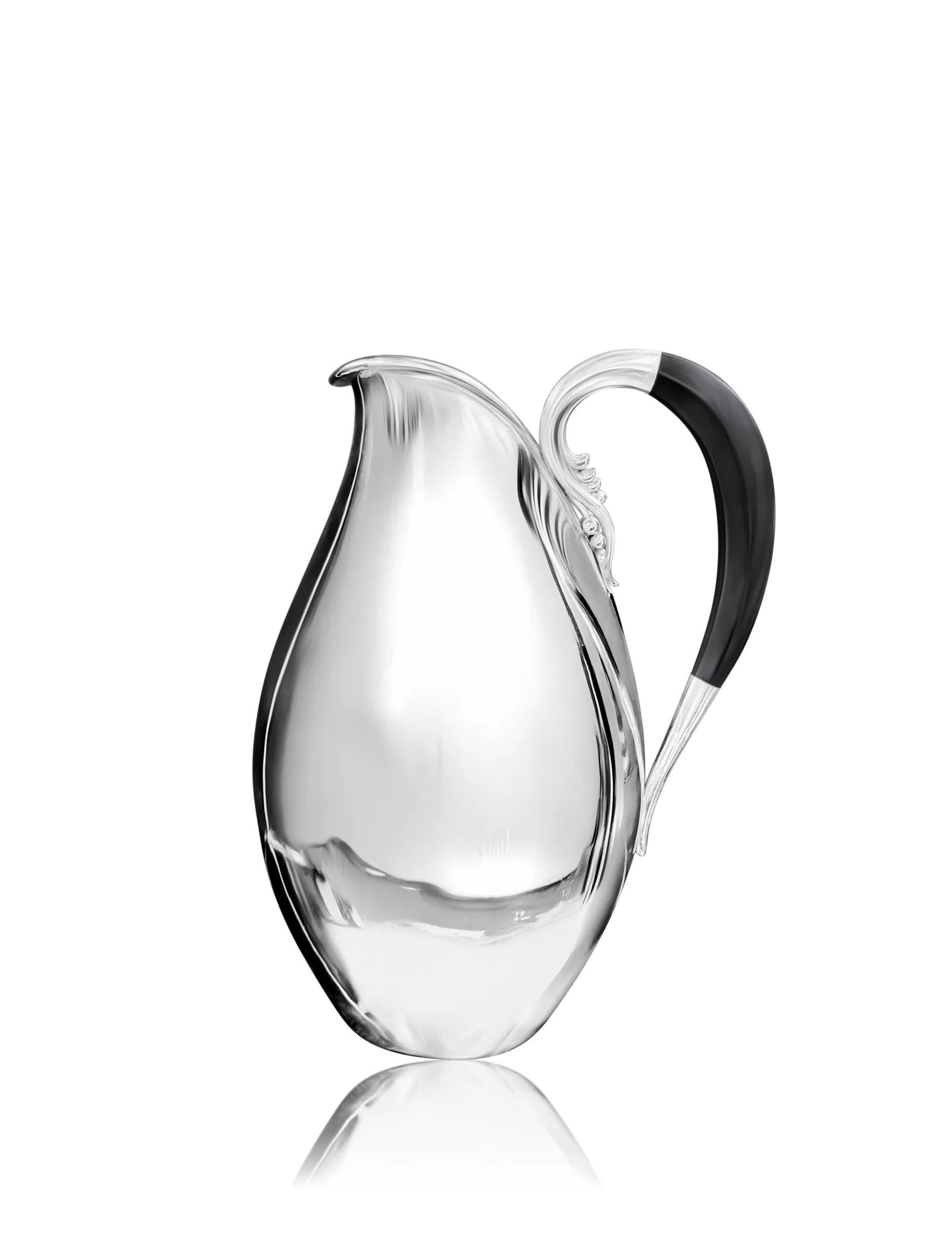 A vintage extra-large sterling silver pitcher, designed by Johan Rohde for Georg Jensen in 1931, embodies the essence of Art Deco elegance. Its organic silhouette begins with a round foot and gracefully expands into a wide body, tapering to a narrow