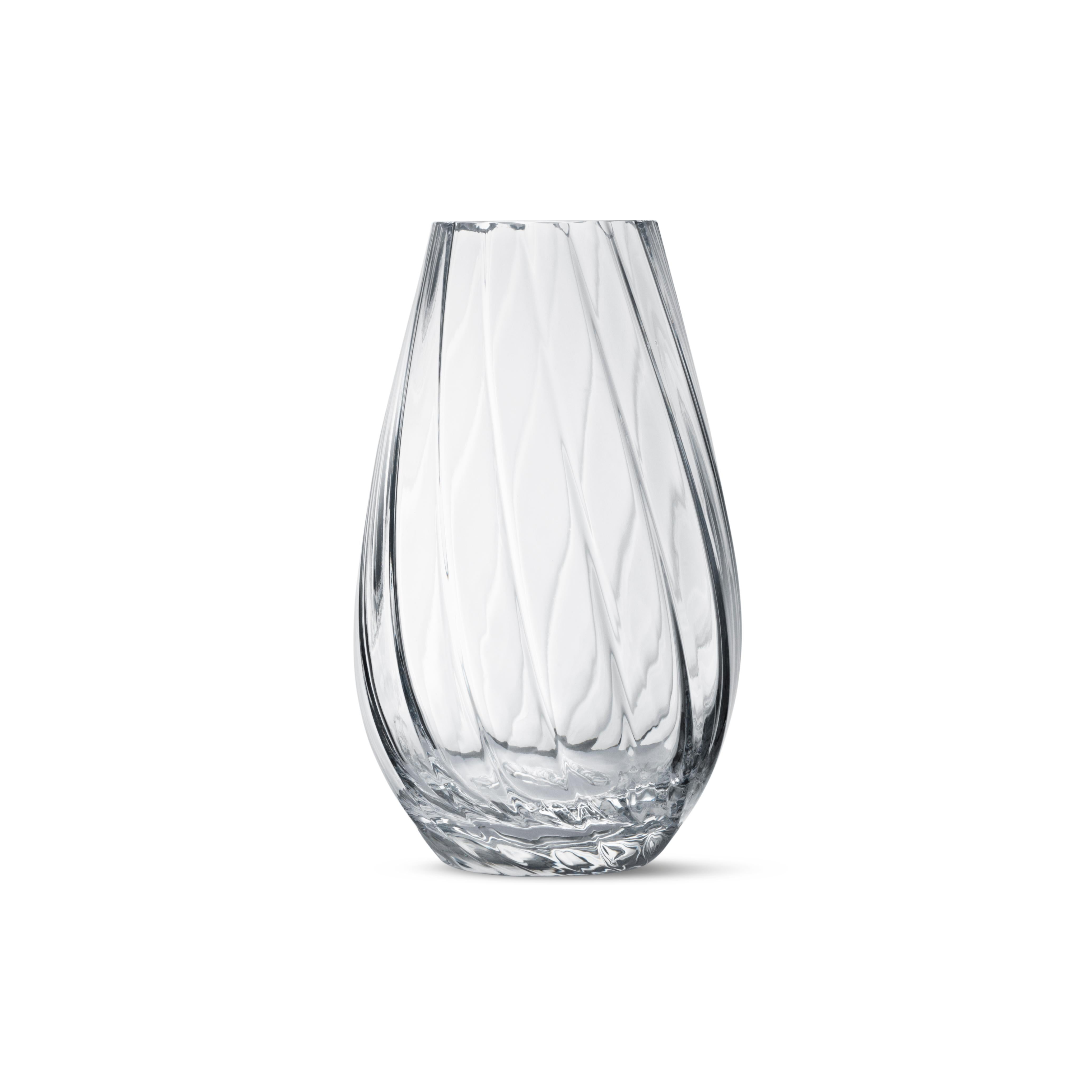 With a narrow mouth and wide base, the bulbous form of a Facet vase is perfect for displaying full bouquets. The vase is decorated with light-reflecting facets that add dimension and character. Seemingly at odds with one another, the lines and
