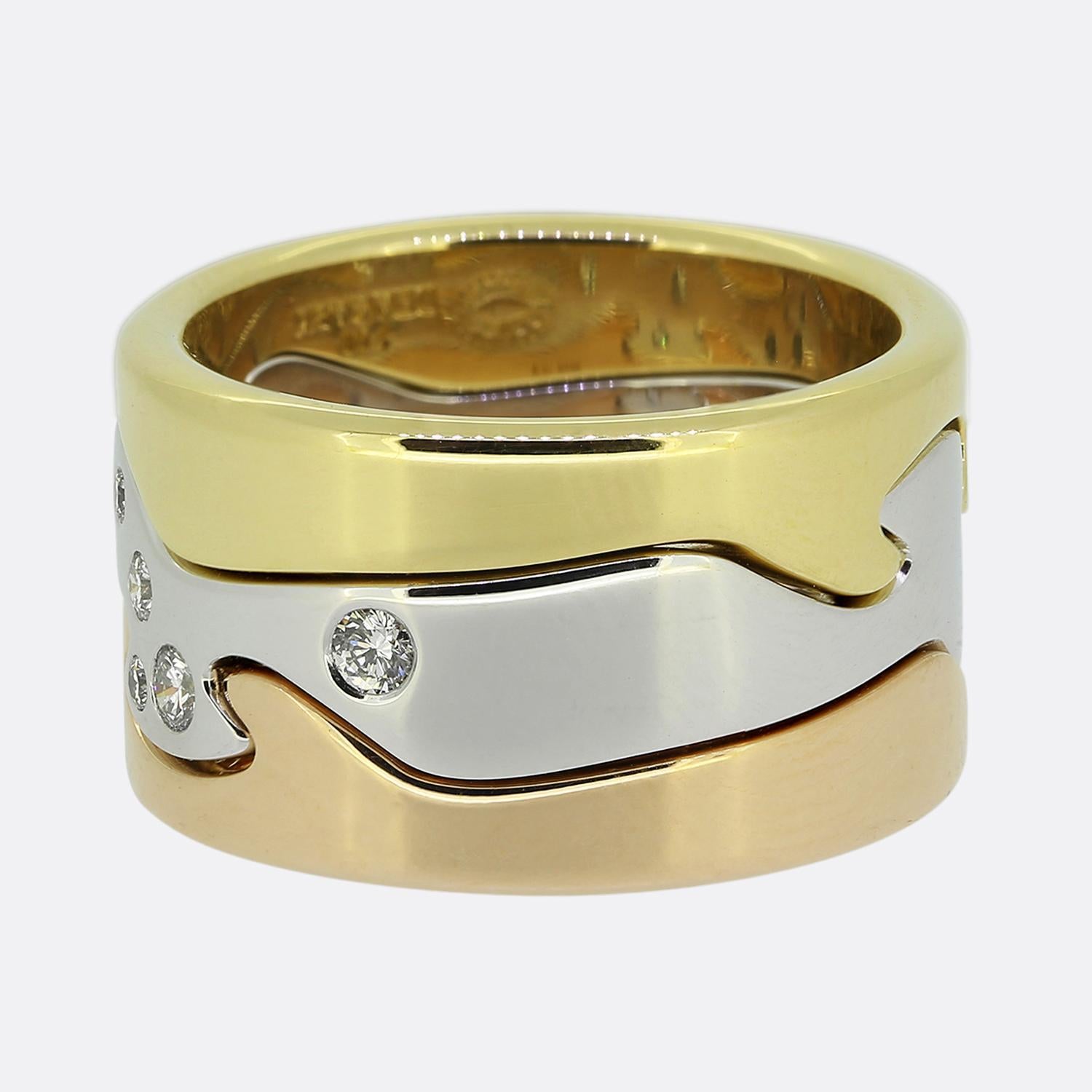 Ecco un iconico set di anelli di Georg Jensen. Il design è caratterizzato da un trio di fasce intrecciate in oro 18 ct, ciascuna in una tonalità diversa: oro giallo, oro bianco e oro rosa. La fascia centrale bianca è impreziosita da diamanti bianchi