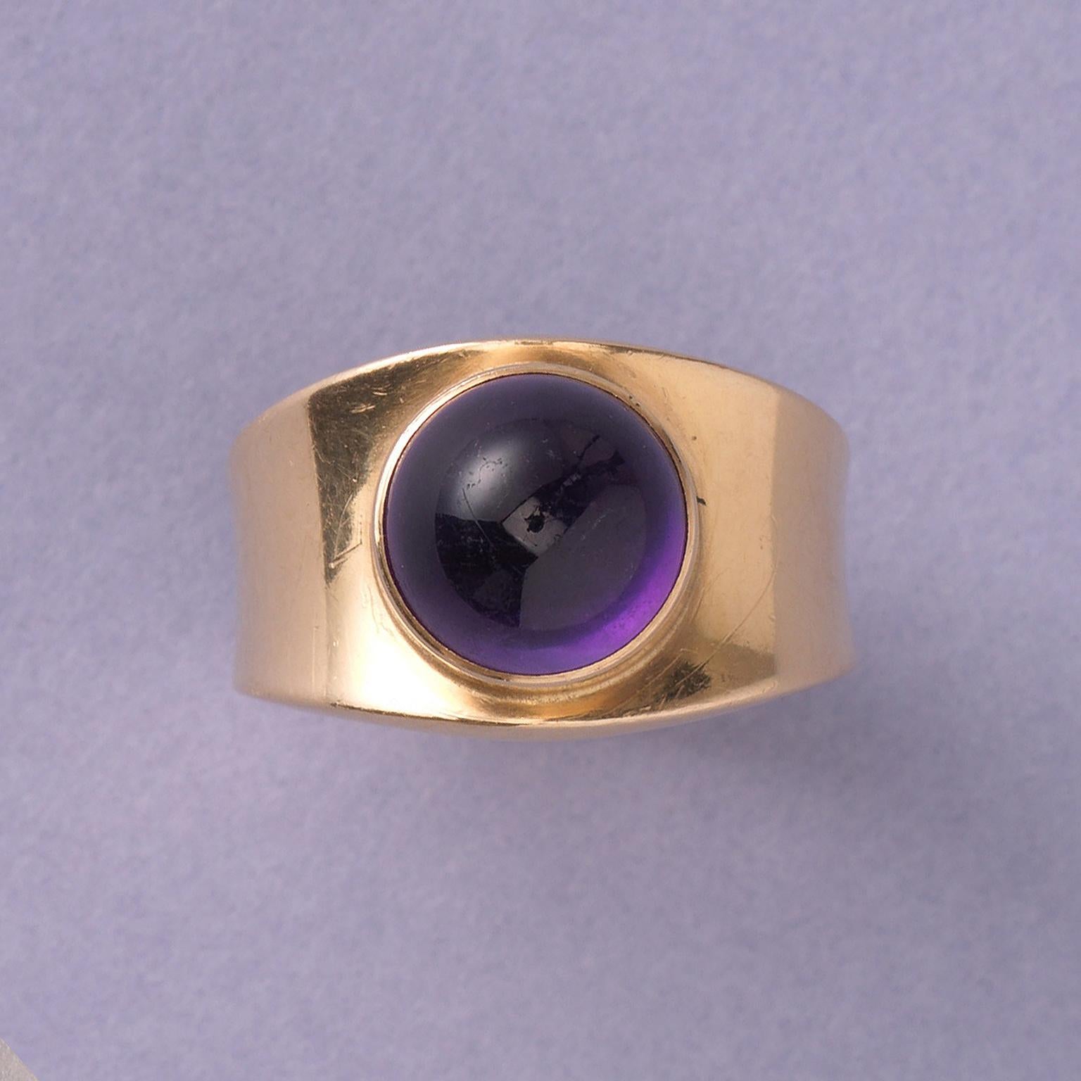 An 18 carat yellow gold band ring set with a cabochon cut amethyst, signed and numbered: Georg Jensen, 1124, Denmark, 1967. 

weight 9.86 grams
width: 2 cm
ring size: 16.75 mm / 6 1/4 US
