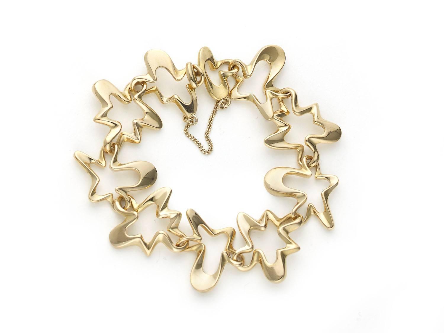 A Georg Jensen, 18ct gold, “Splash” bracelet, brooch and earrings suite, of open amoebic form, by Henning Koppel. Signed Georg Jensen, 18k 750, Circa 1955.
Bracelet approximately 7.5