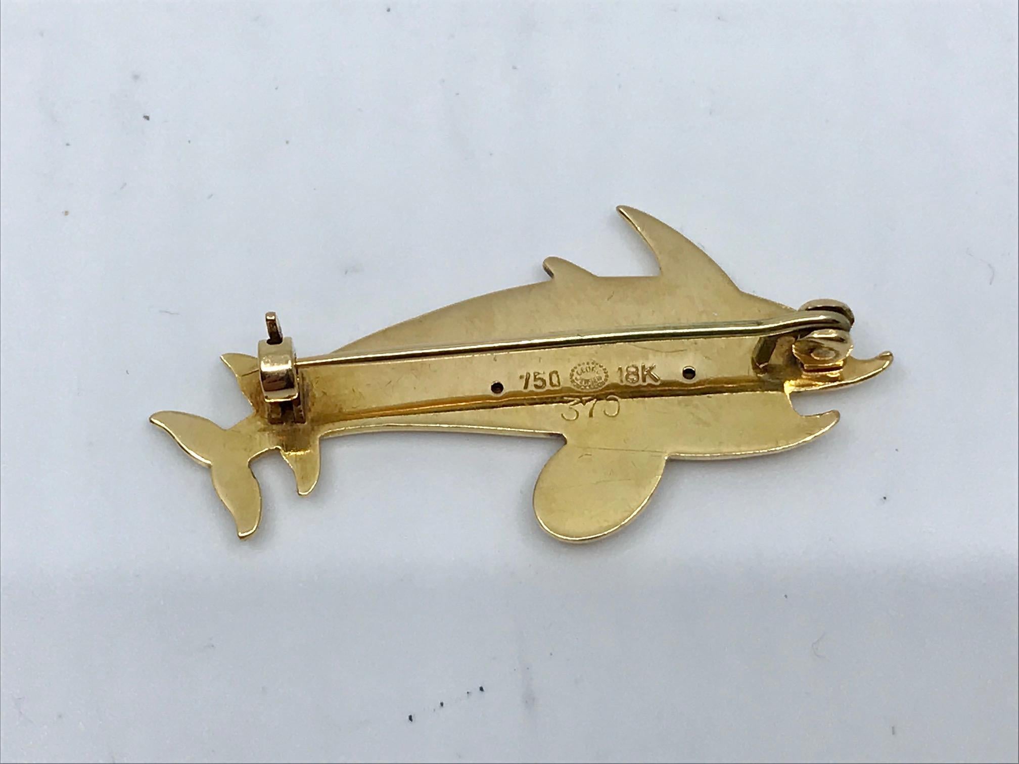 This is an 18kt gold Georg Jensen brooch with dolphin motif, design #370 by Arno Malinowski from circa 1952.

Measures 1 5/8″ x 3/4″ (4cm x 2cm). Georg Jensen changed their numbering system for gold jewelry sometime after the war, this piece is from