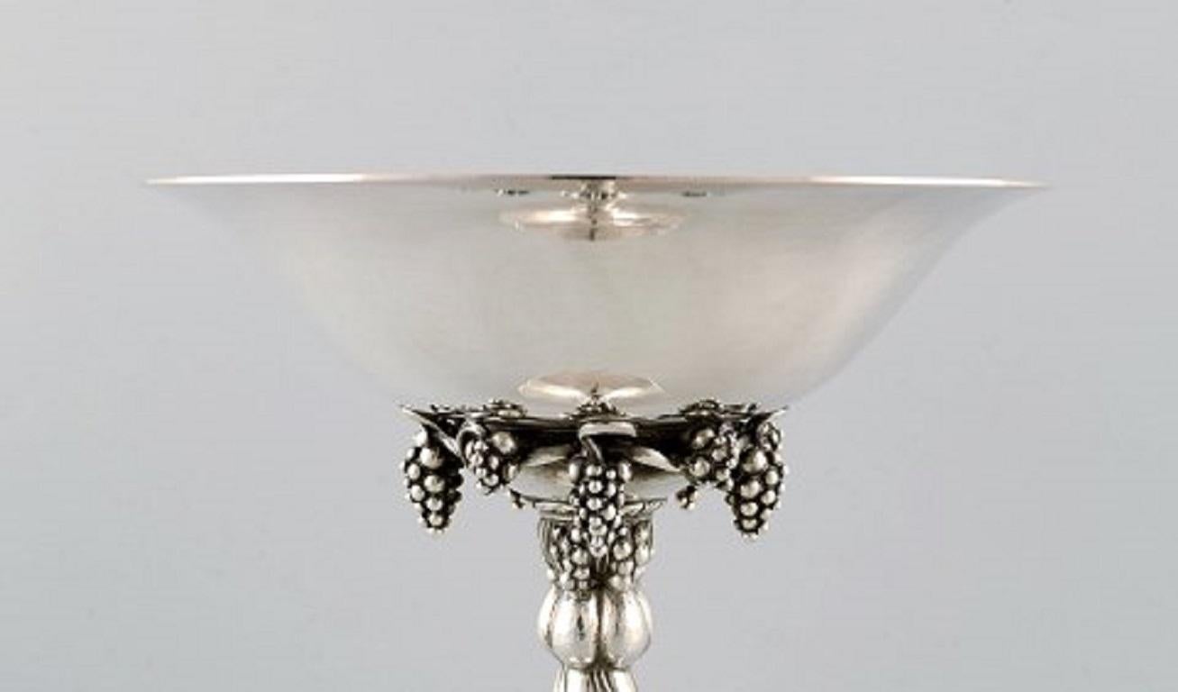 Georg Jensen grape centrepiece in sterling silver. Model number 263.
In perfect condition.
Stamped: 263B / T10.
Weight: 625 grams.
Measures: Height 19 cm, diameter 18 cm.
A pair of centrepieces in stock.