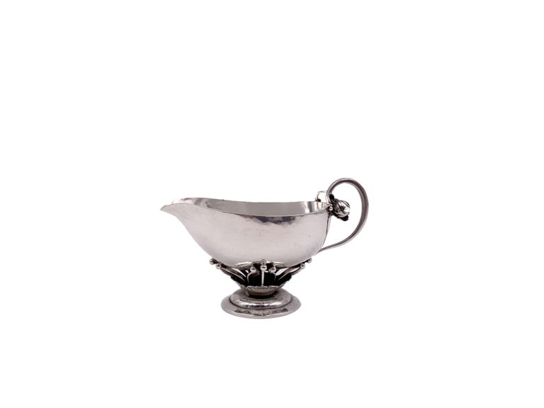 Georg Jensen sterling silver, hand-hammered creamer, measuring 3 1/2''in length by 2'' in height, and sugar basket, measuring 3 1/2'' in length by 3'' in height, in renowned Blossom pattern number 235C from the 1930s, both bearing hallmarks as