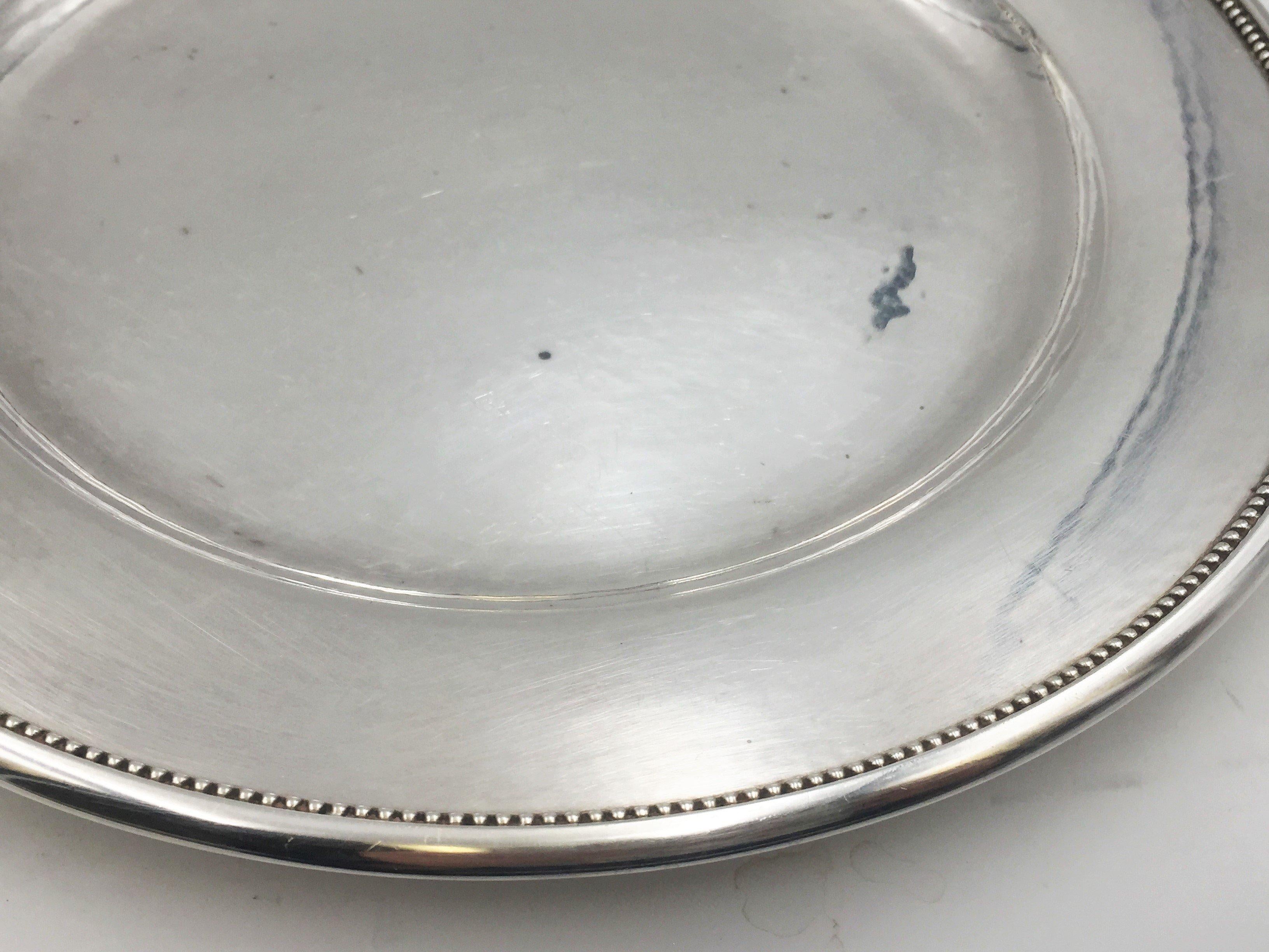 Beautiful Georg Jensen hand hammered sterling silver round plate / platter/ tray in pattern 210F measuring 10 1/4'' in diameter and with beaded rim. Weight is 19 troy ounces. Bearing hallmarks as shown.

Danish silversmith Georg Jensen (1866-1935)