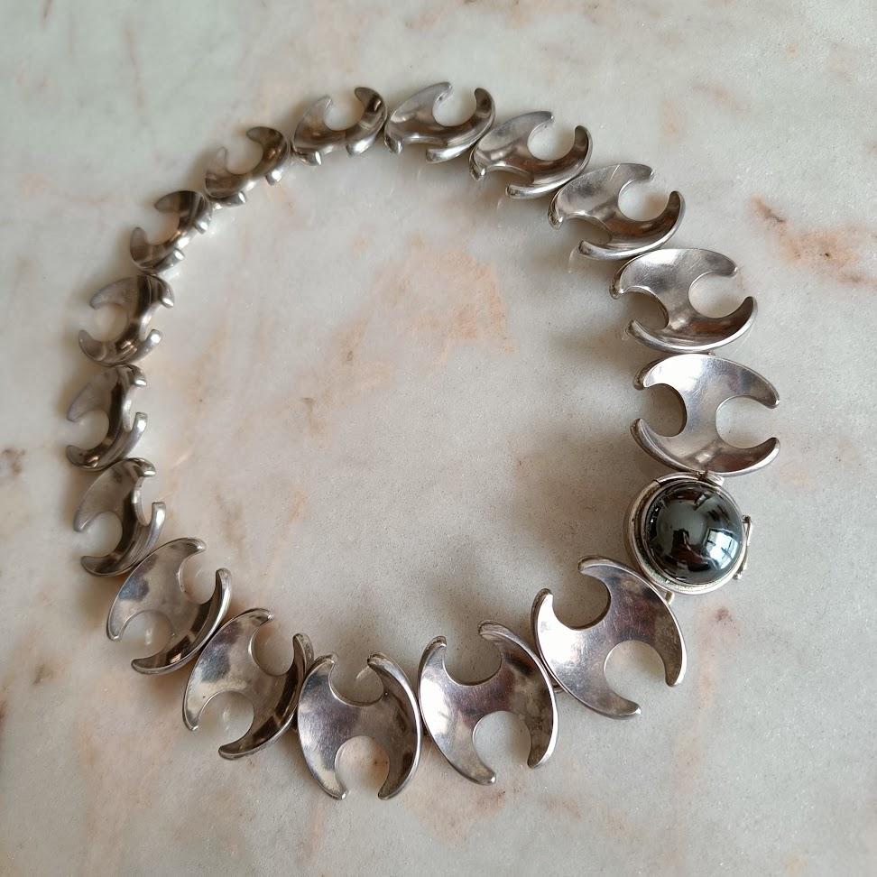An exceptional sterling silver necklace, model 130B, designed by the celebrated Henning Koppel (1918–1981) for the renowned Danish silversmithy Georg Jensen.

This stunning piece features Koppel’s signature organic, sculptural links accented by a