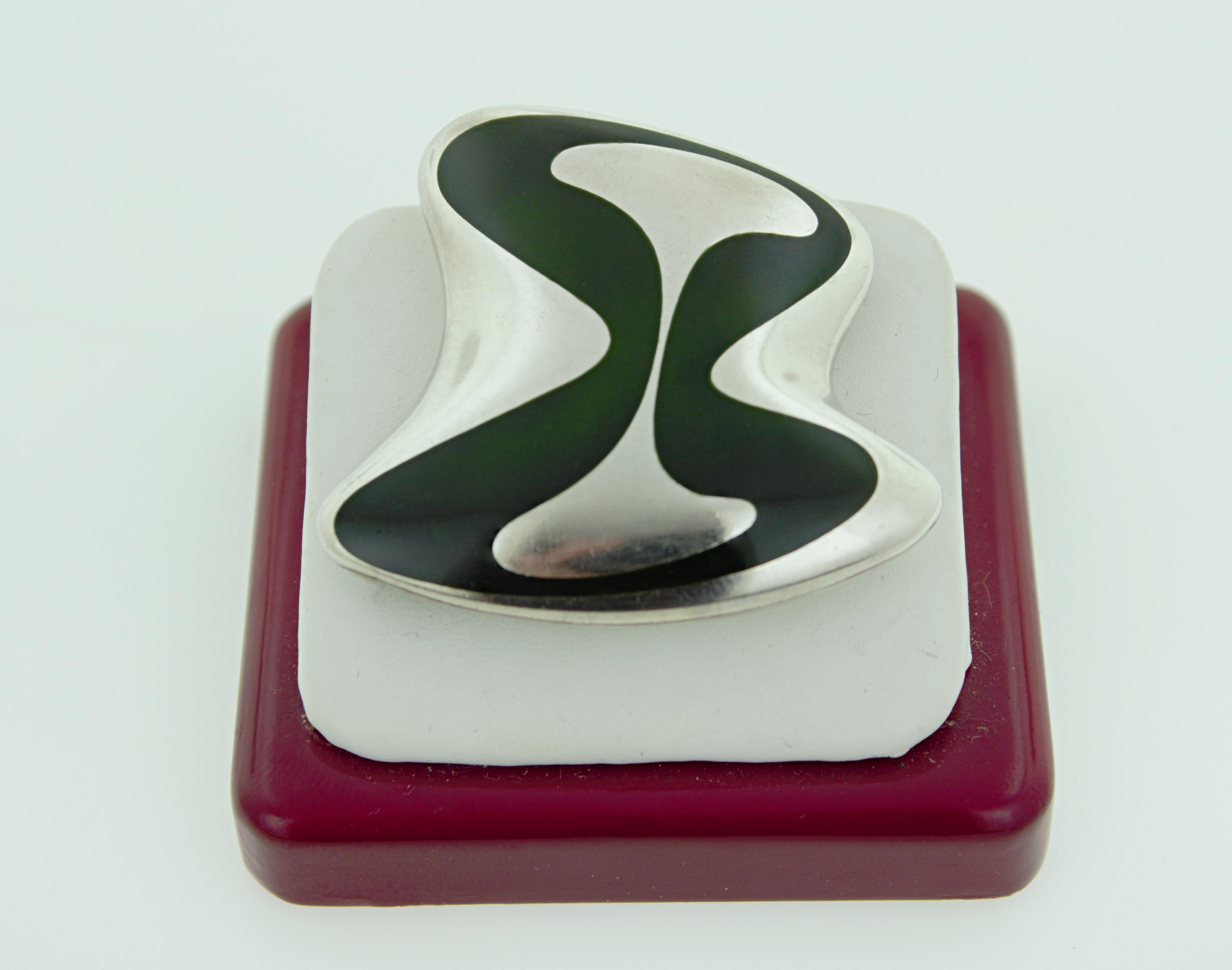 Featuring dark green enamel, in sterling silver modern amorphous high
polished brooch, 45 X 26.7 X 9.5 mm, marked HK encircled, Georg Jensen,
sterling Denmark, 315, Gross Weight 17.48 grams.
Circa: 1954
Henning Koppel designed for Georg Jensen from